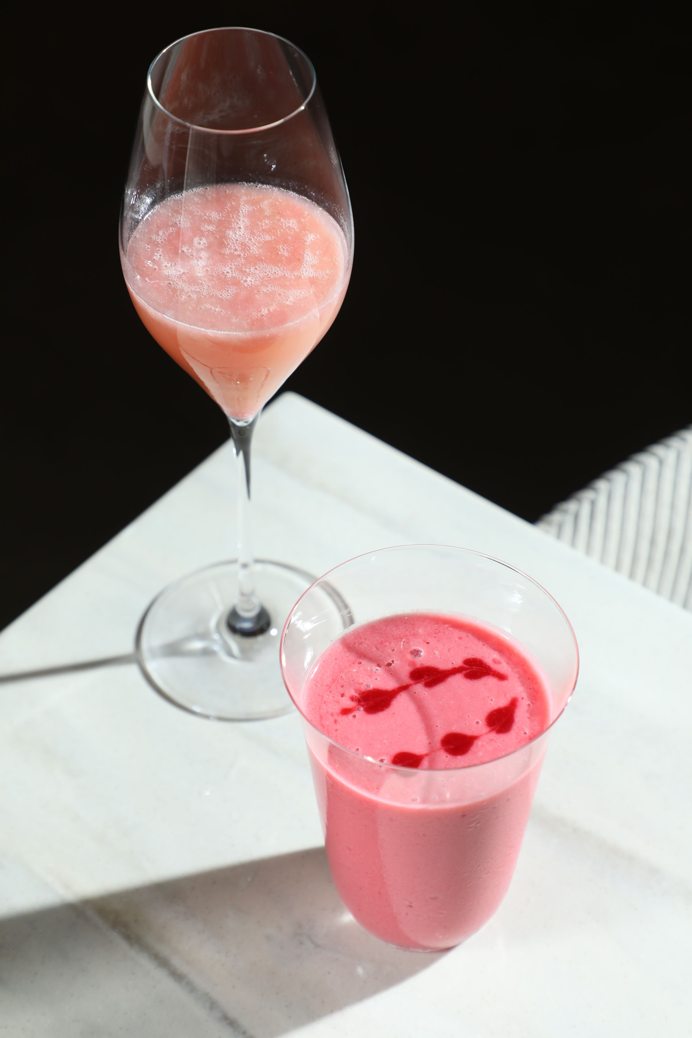 春天適合來杯粉嫩調酒「Bellini, Prosecco, Peach」（後）或無酒精的鮮打果昔「Grape, raspberry, osmanthus, honey, yogurt」（前）。（皆300元／杯）