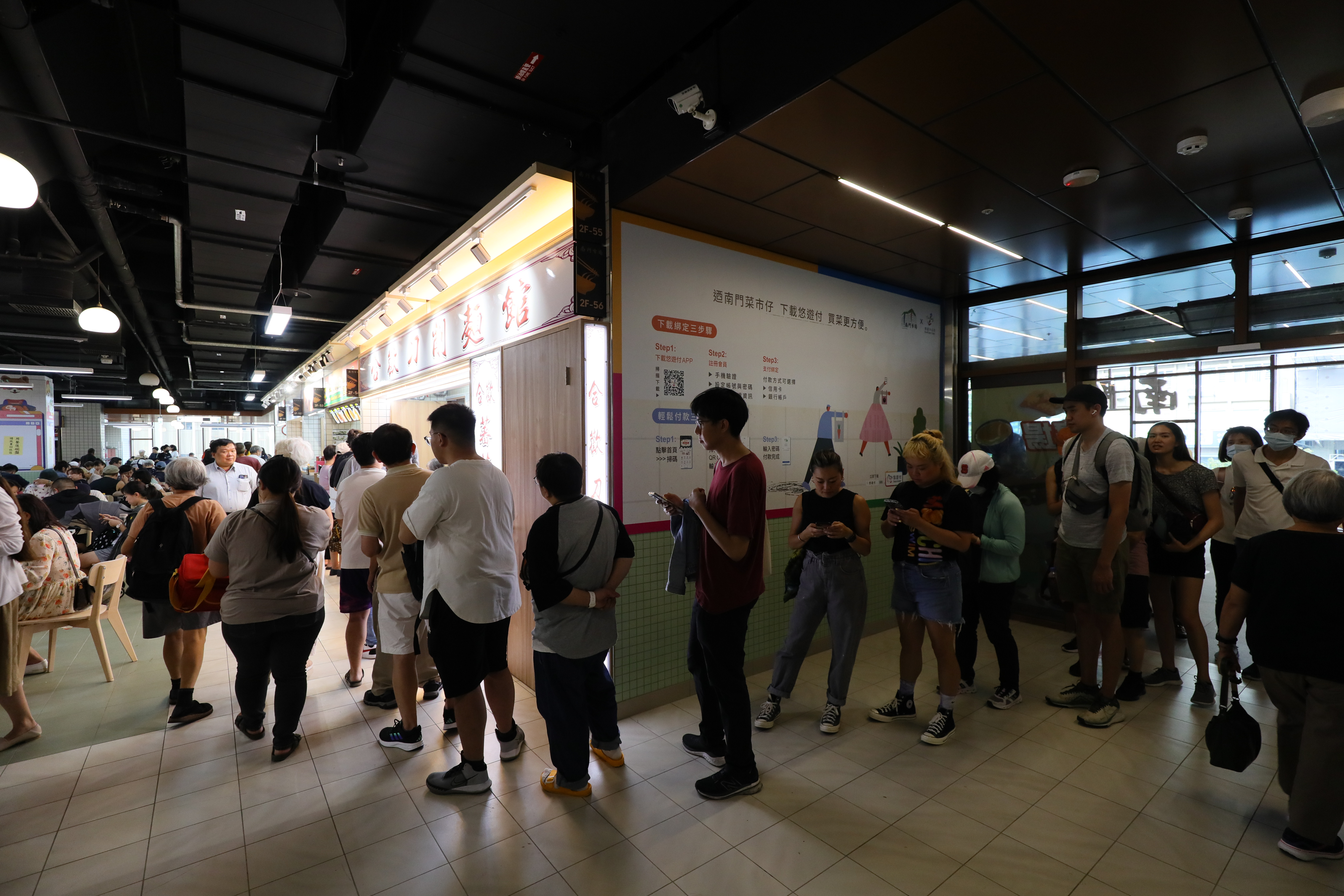 「合歡刀削麵館」的排隊人龍從攤位前一直排到手扶梯口。