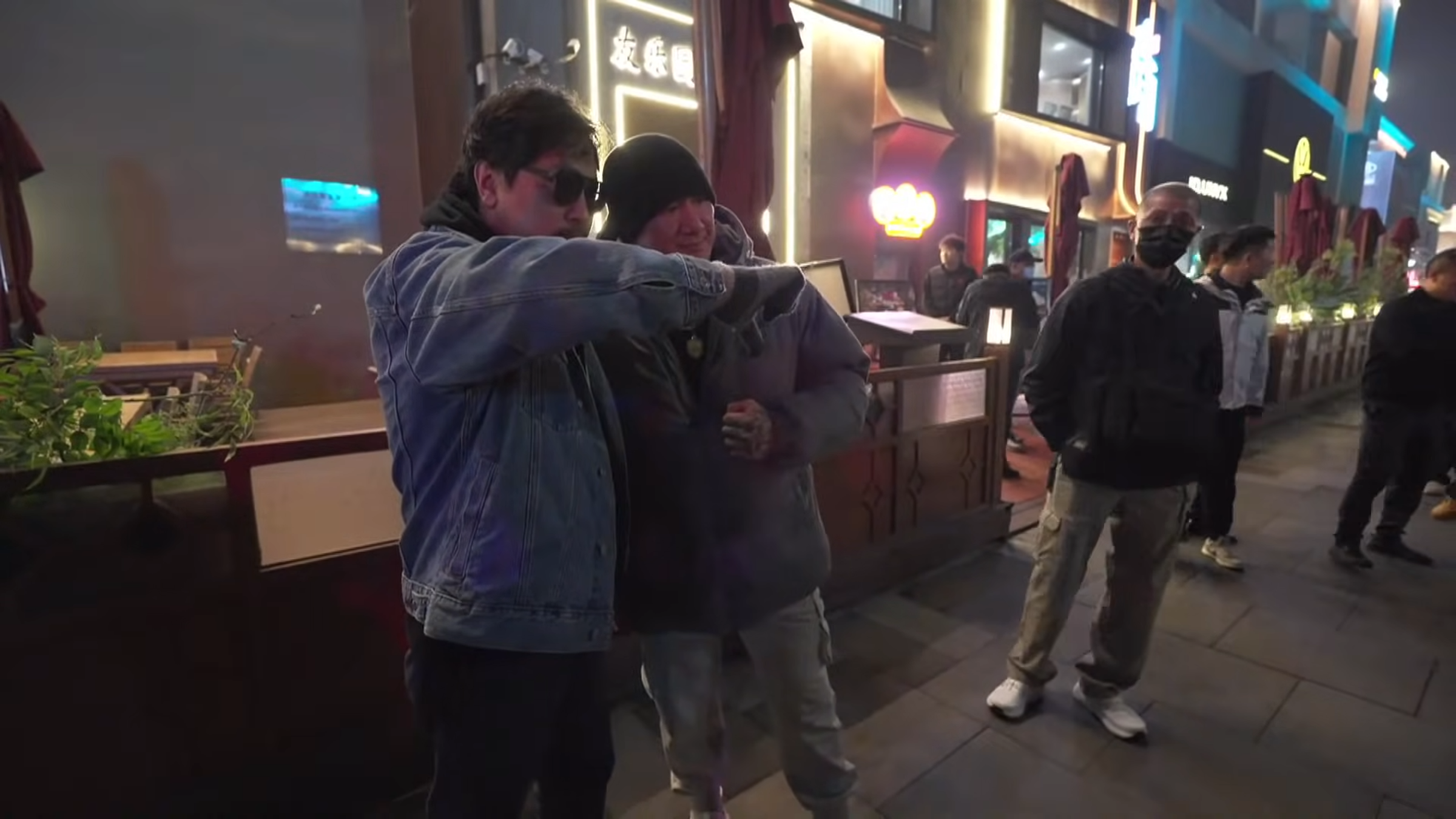館長在北京直播期間，一名墨鏡男找他合照，卻不僅比了倒讚，還喊出「中國台灣，一邊一國」。（翻攝自 館長惡名昭彰 YouTube直播）