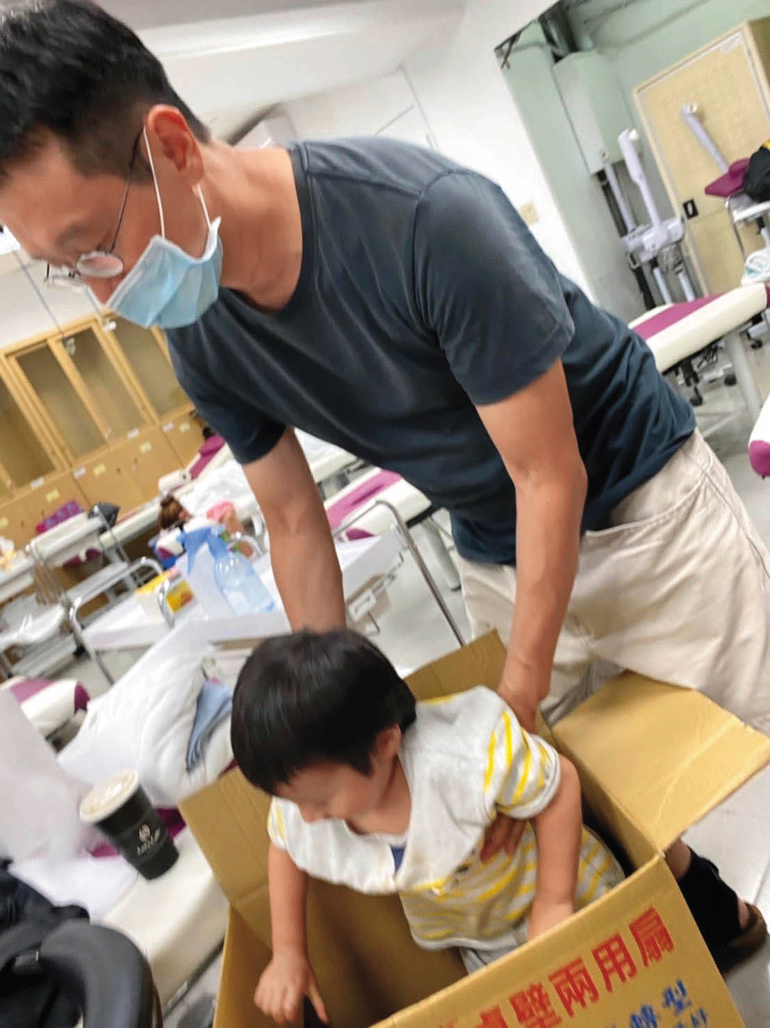 譚端帶著孩子上傳統整復推拿課，孩子在紙箱玩耍與睡覺。（譚端提供）