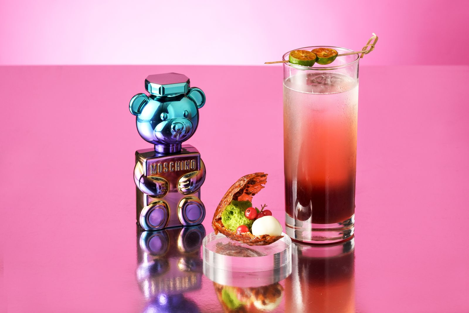 MOSCHINO PARFUM中的「珍珠熊女性淡香精」,則以外觀精緻的「杏仁貝殼、檸檬珍珠」(左)呈現,將杏仁糖片化作貝殼形象,以檸檬慕斯製成乳白珍珠;搭配漸層色系調酒「Bear Pearl」(右)將澳洲茶樹、檜木和茉莉花茶加入琴酒舒肥後為基底,搭配巨峰葡萄利口酒與果汁,再注入檜木苦精與薑汁啤酒豐富層次。(台北W飯店提供)