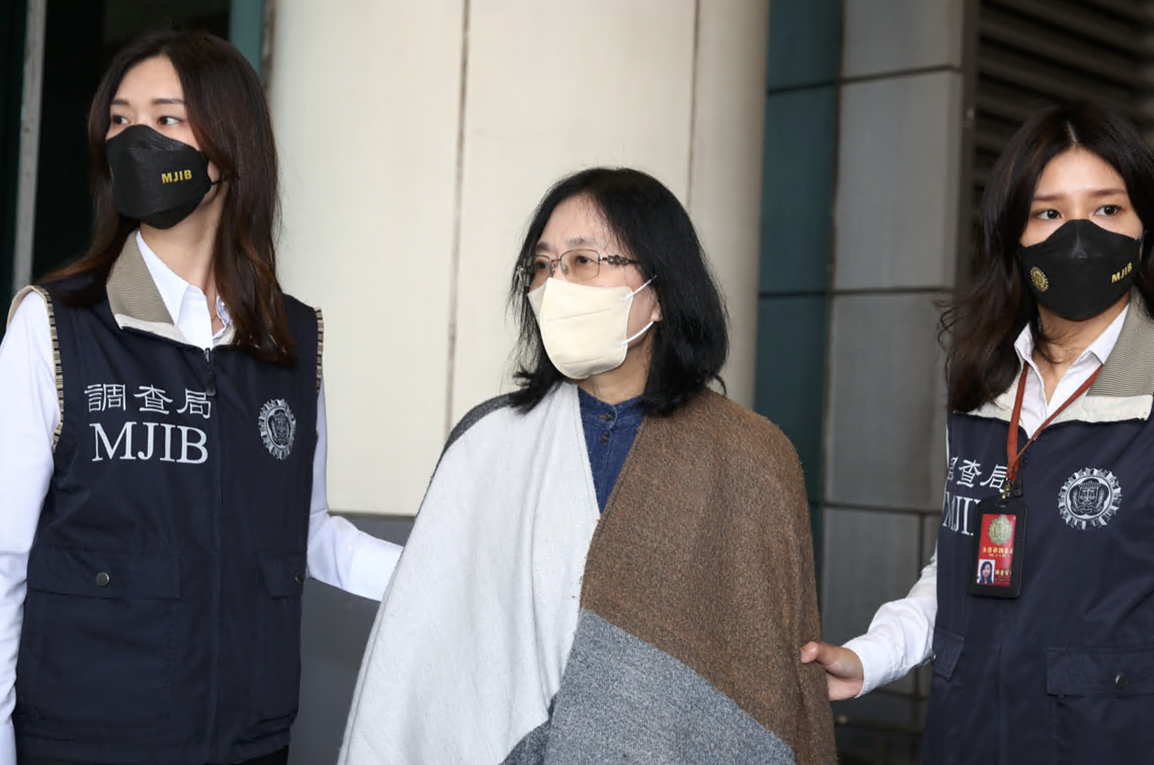 黃林麗真（中）今早抵達桃機，被解送至士檢歸案。