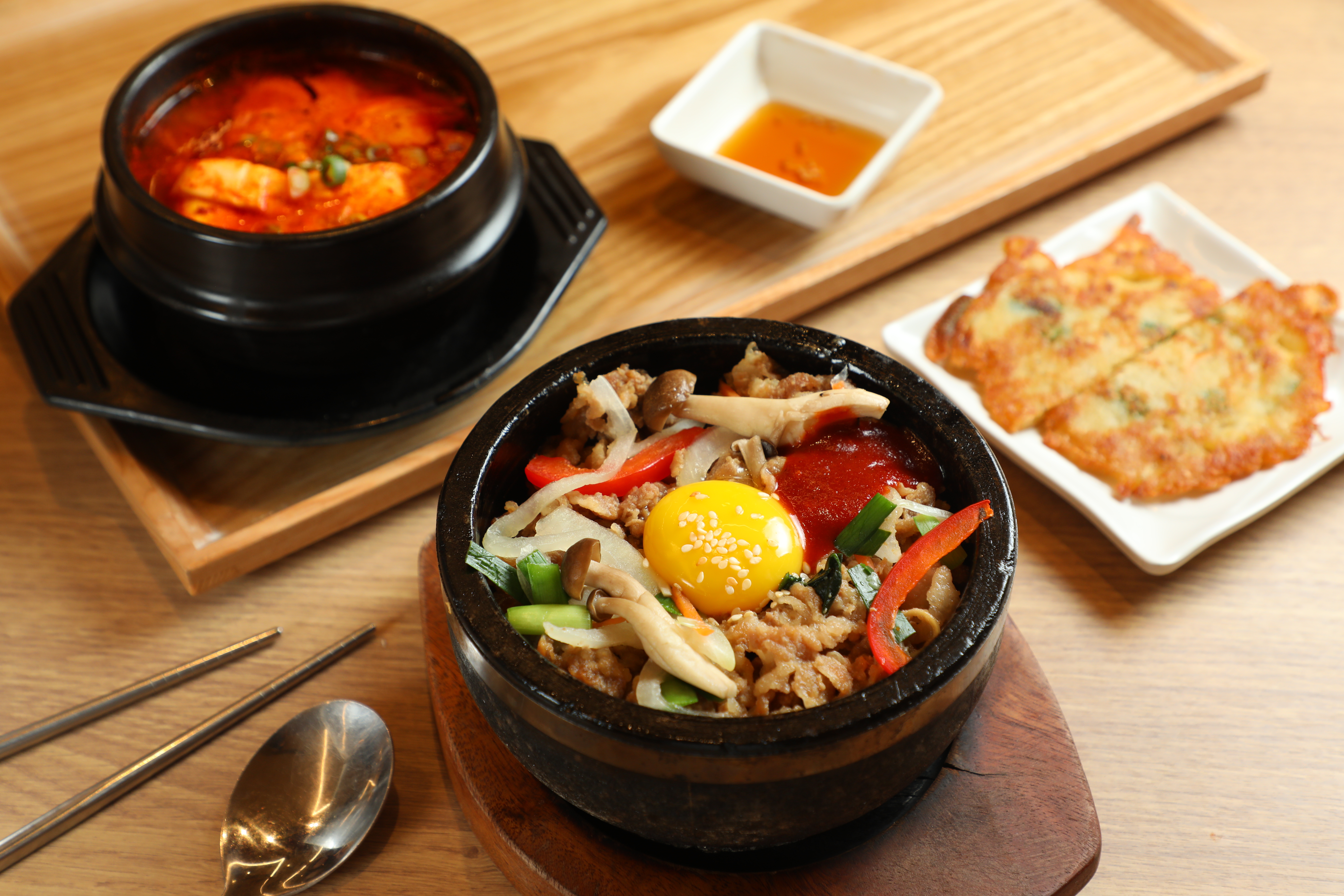 韓美膳半半套餐中的「豬五花石鍋拌飯&海鮮豆腐鍋」都以小鍋盛裝,套餐附上2小塊海鮮煎餅。(348元/份)