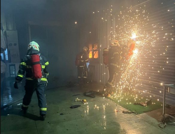 辦公室內5名移工原試圖自行撲滅,但火勢過大,後通報消防人員破門灌救。(翻攝畫面)