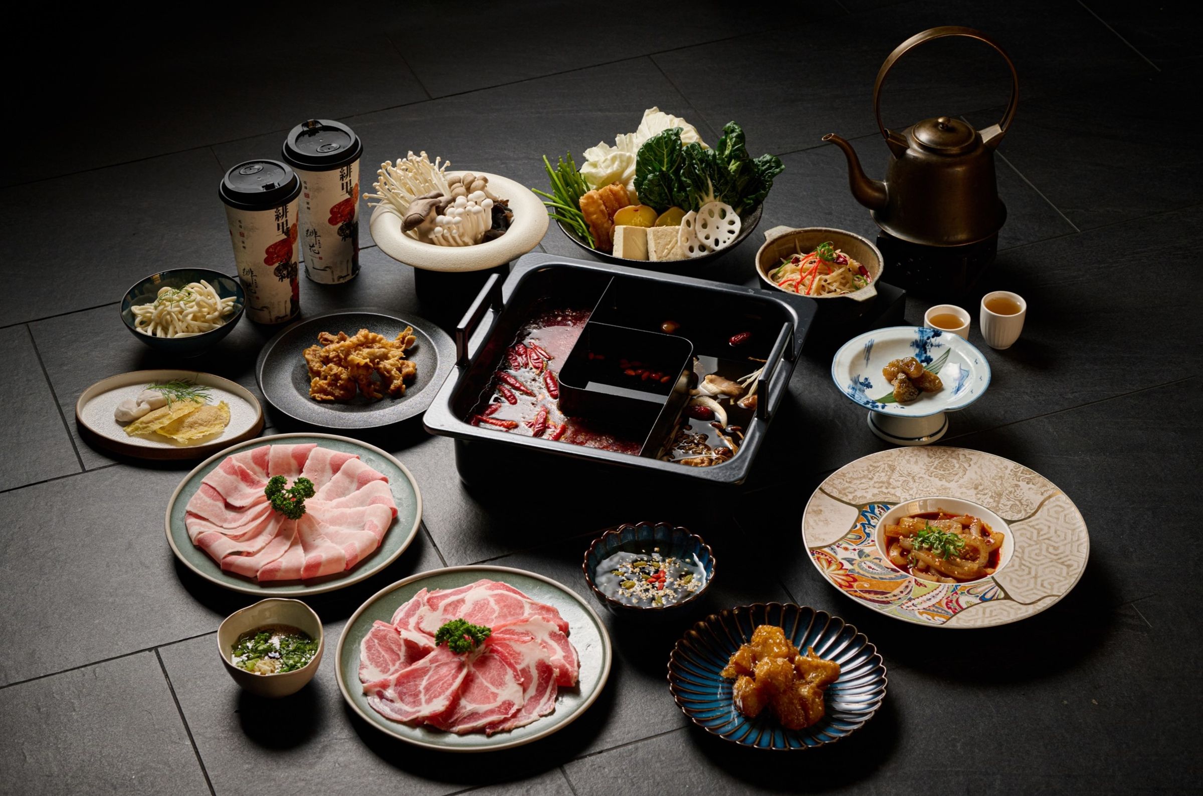 台中「重慶火鍋緋花」3月新推「古早味魷魚蒜鍋」和「鹽麴麻油雞鍋」,讓饕客能以鴛鴦鍋方式和辣鍋一起品嘗。(緋花提供)