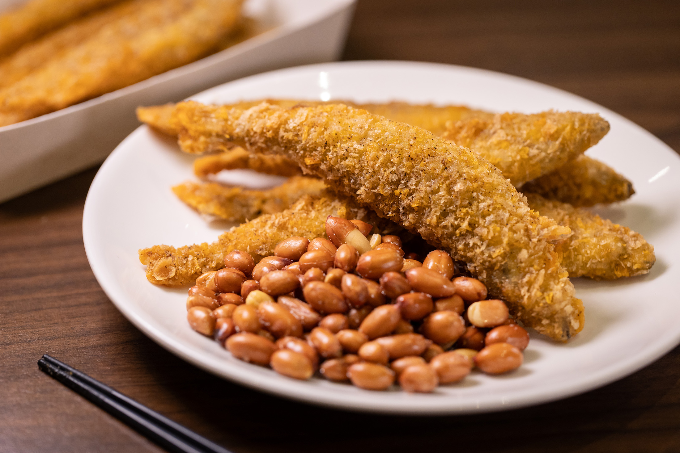能吃到飽滿魚卵與彈牙口感的炸物「柳葉魚」（後，150元／份）與口感清脆的「鹽炒花生」（前，50元／份），是很棒的下酒菜組合。