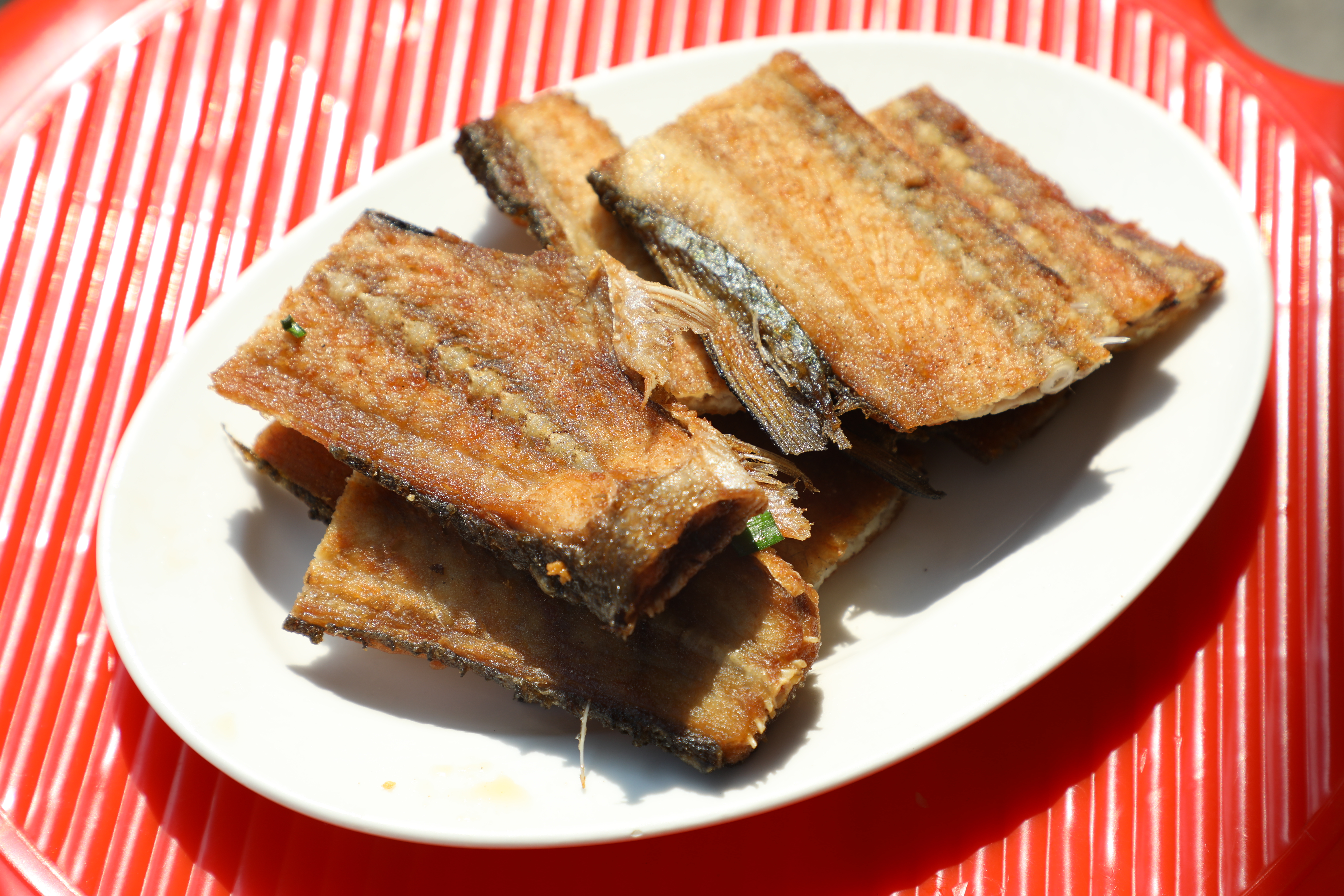 變廢為寶的「香煎魚背骨」乍看很像白帶魚,越吃越涮嘴。(60元/份)