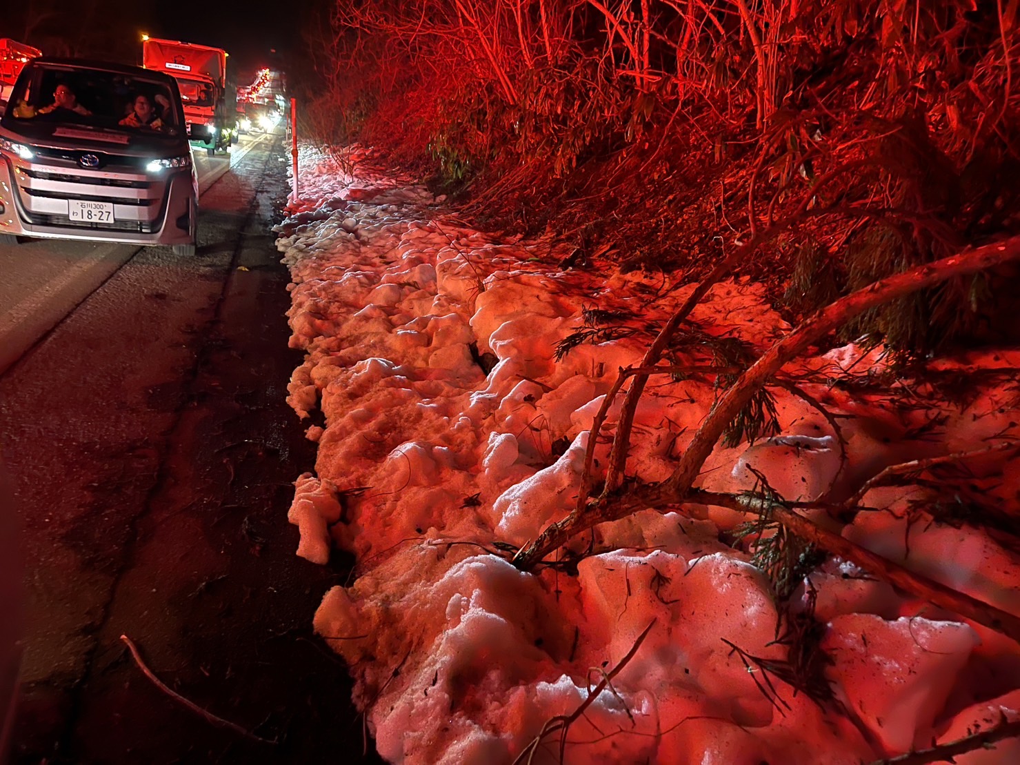 路邊白雪在車陣煞車燈、救護車警示燈的照映下，猶如血染的丰采。