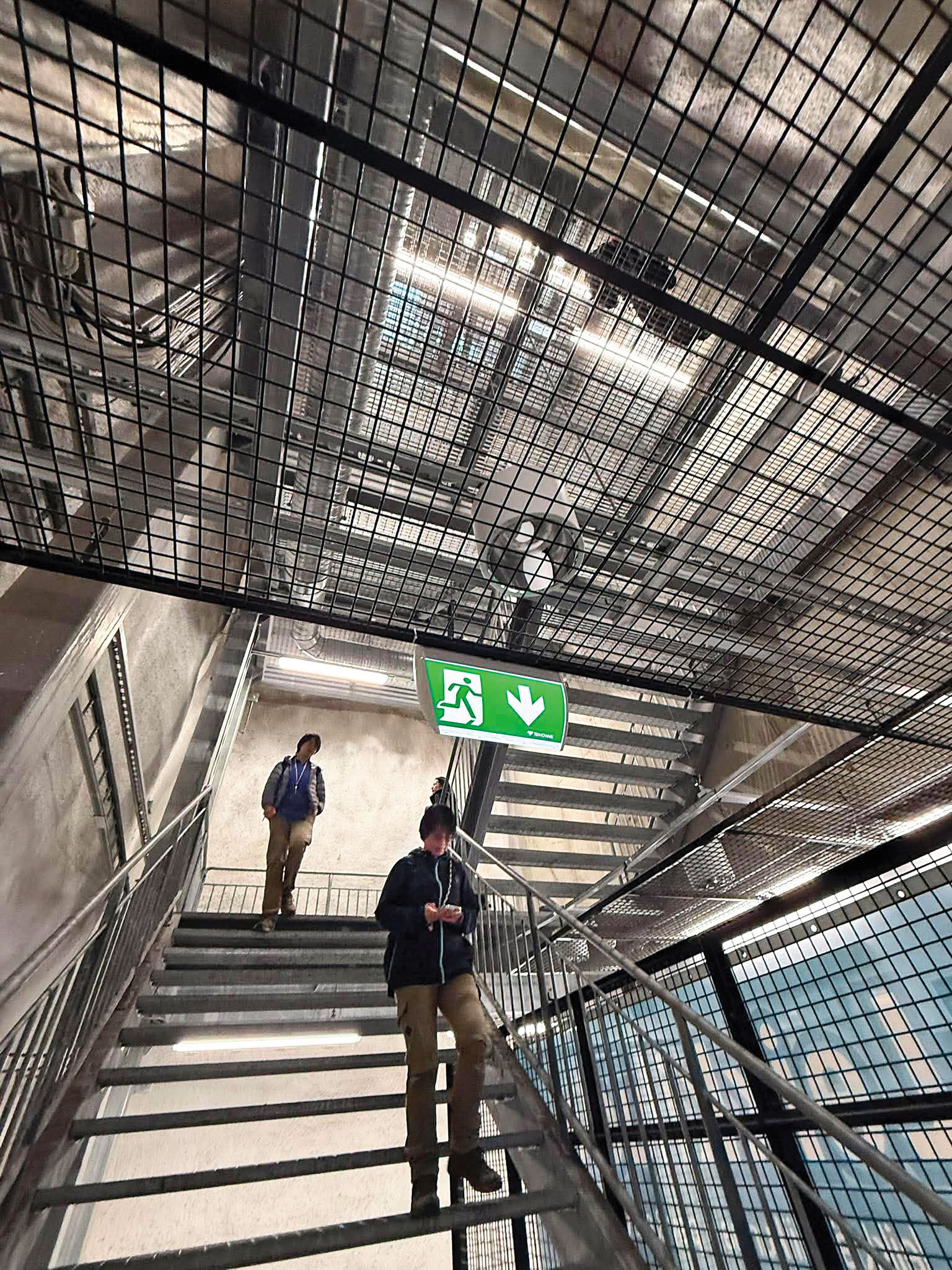 走到運動場最下層抬起頭看，仍有一層擋板，整體樓梯通透感十足。