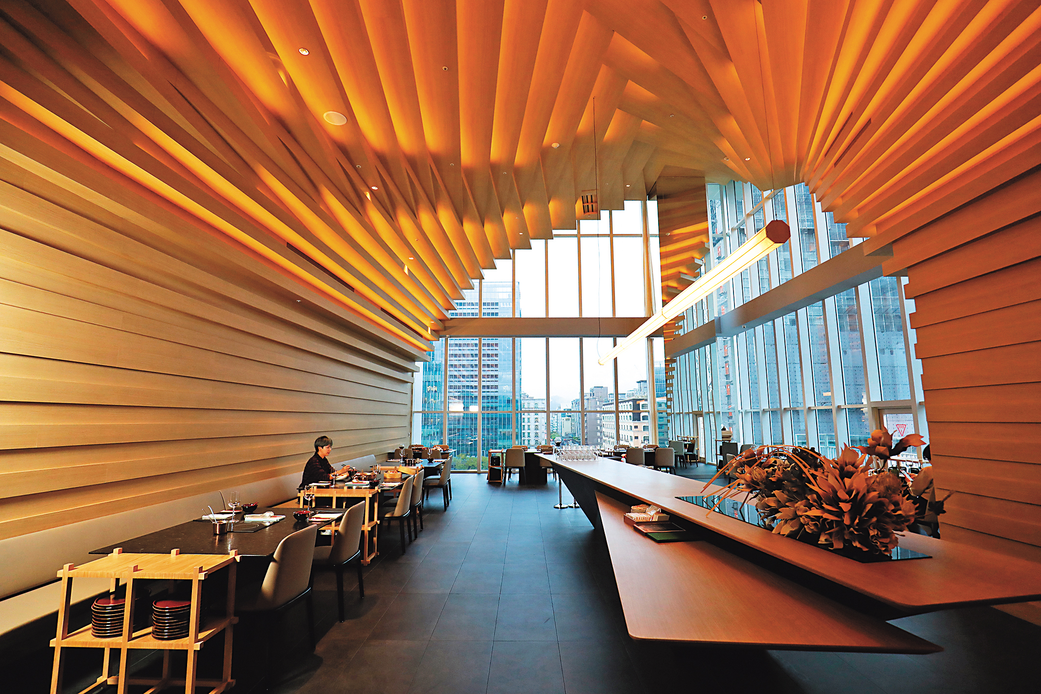 餐廳空間邀請到建築大師隈研吾親自設計,以大量木質建材為主軸,營造有如置身巨大海蝕洞中的包覆感。