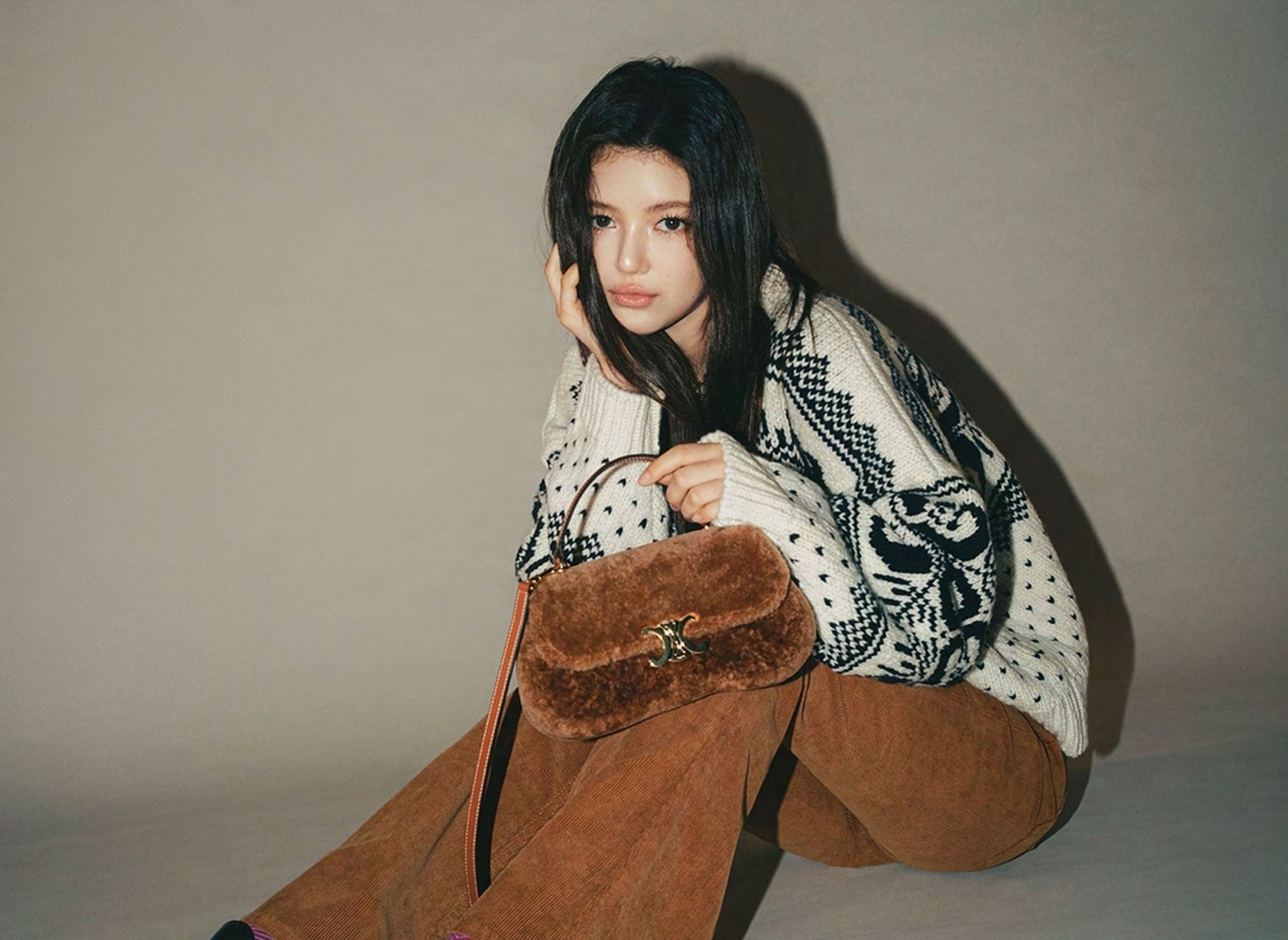 .韓國女團NewJeans的Danielle身上行頭：Triomphe費爾島羊毛圓領毛衣、Marco燈芯絨牛仔褲NT$45,000、ess拋光牛皮革樂福鞋、Teen CELINE Lola羊毛革及牛皮革手袋NT$110,000。（CELINE提供）