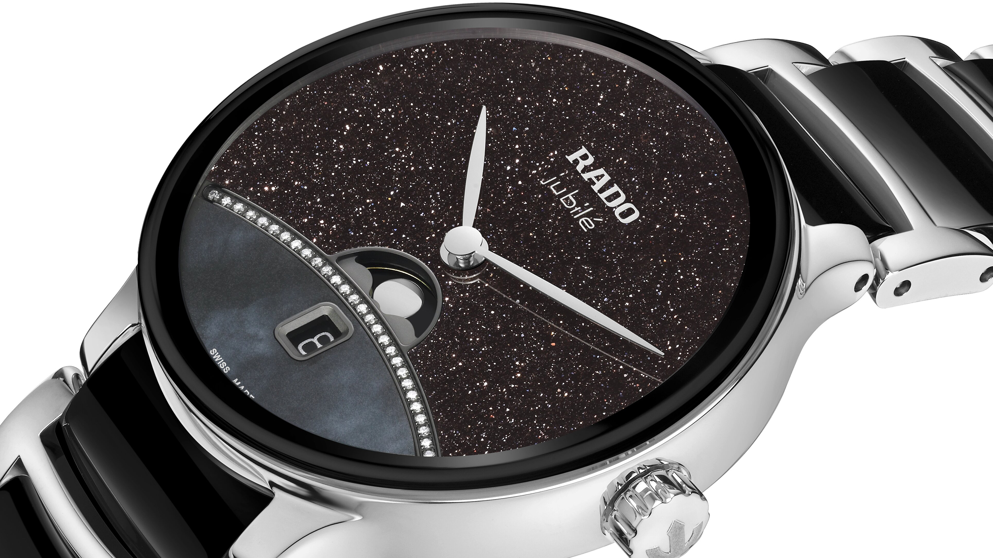 無邊框設計式的弧形藍寶石水晶鏡面,邊緣以黑色金屬鍍層點綴,搭配砂金石及珍珠母貝面盤,還加上鑲鑽的弧線設計,營造出璀璨星空的迷幻氛圍。