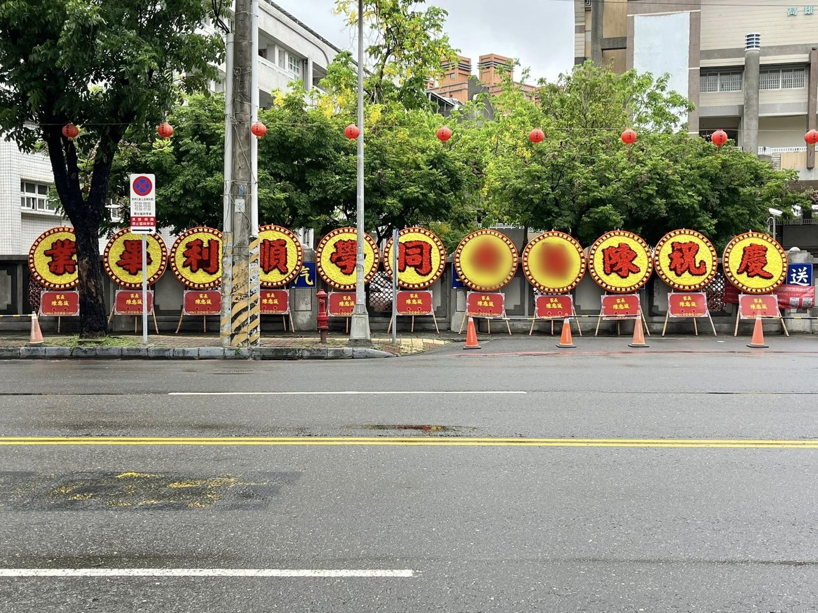 高雄楠梓國中一名爸爸為了慶祝女兒國中畢業,高調訂製了11個巨大花圈擺放在校門口。(翻攝臉書粉專「高雄點 Kaohsiungtien」)