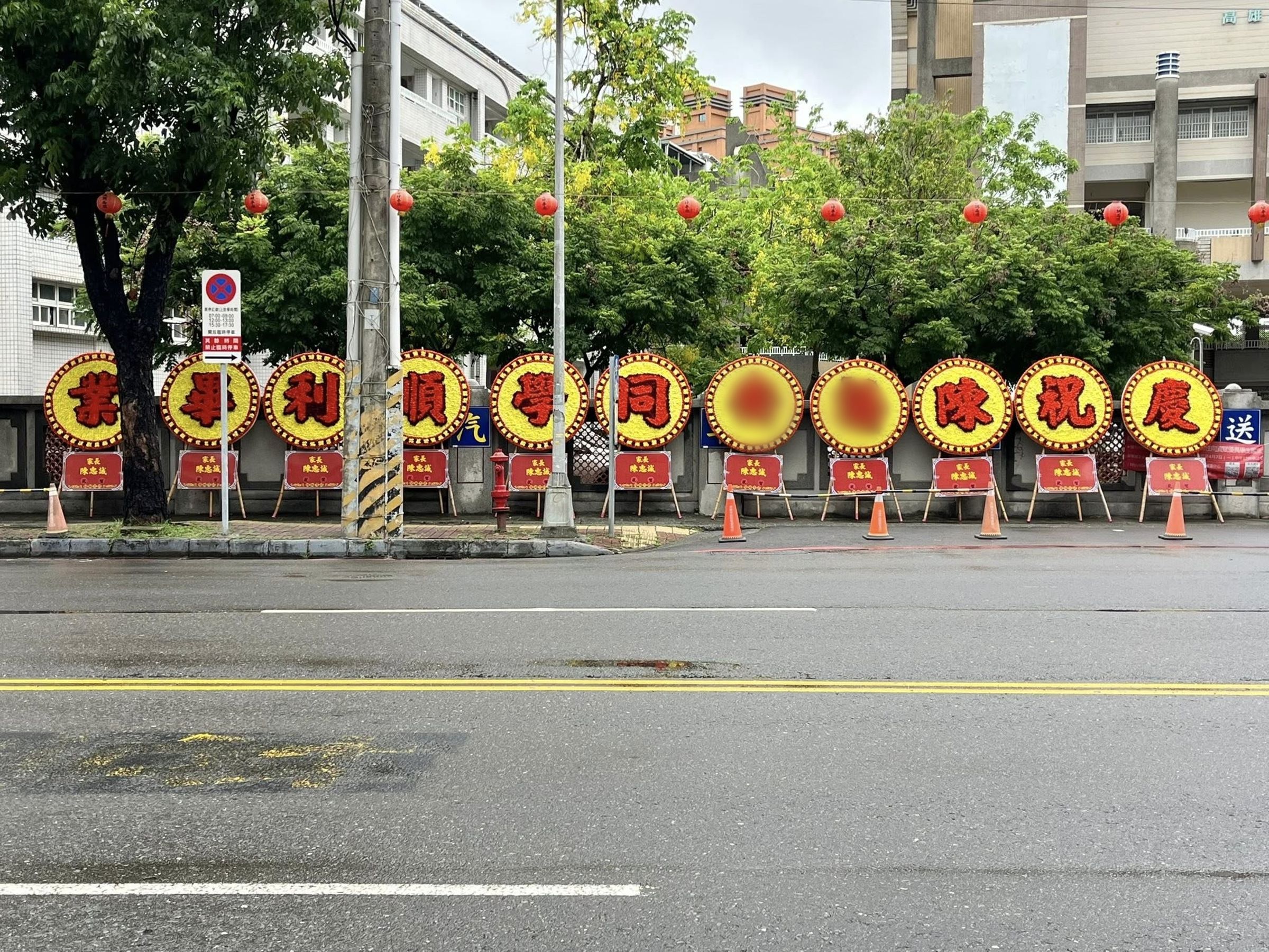 高雄楠梓國中一名爸爸為了慶祝女兒國中畢業,高調訂製了11個巨大花圈擺放在校門口。(翻攝臉書粉專「高雄點 Kaohsiungtien」)