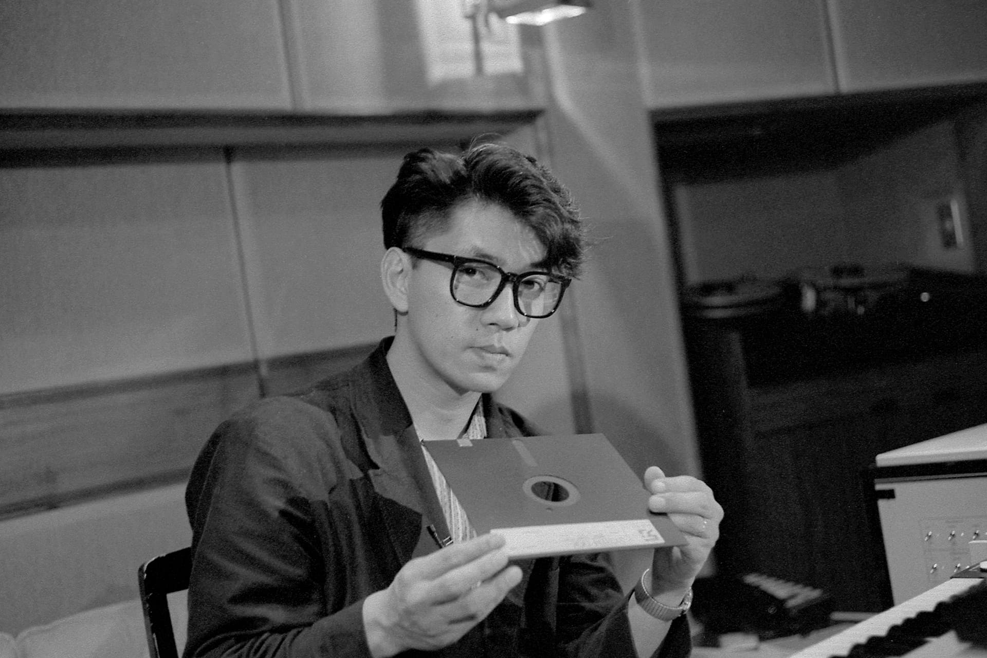 身為電子樂團的先驅，當時坂本龍一手上拿的是當時電腦用的磁碟片，這對現代人來說應該是想都沒想過的發明。（佳映娛樂提供）