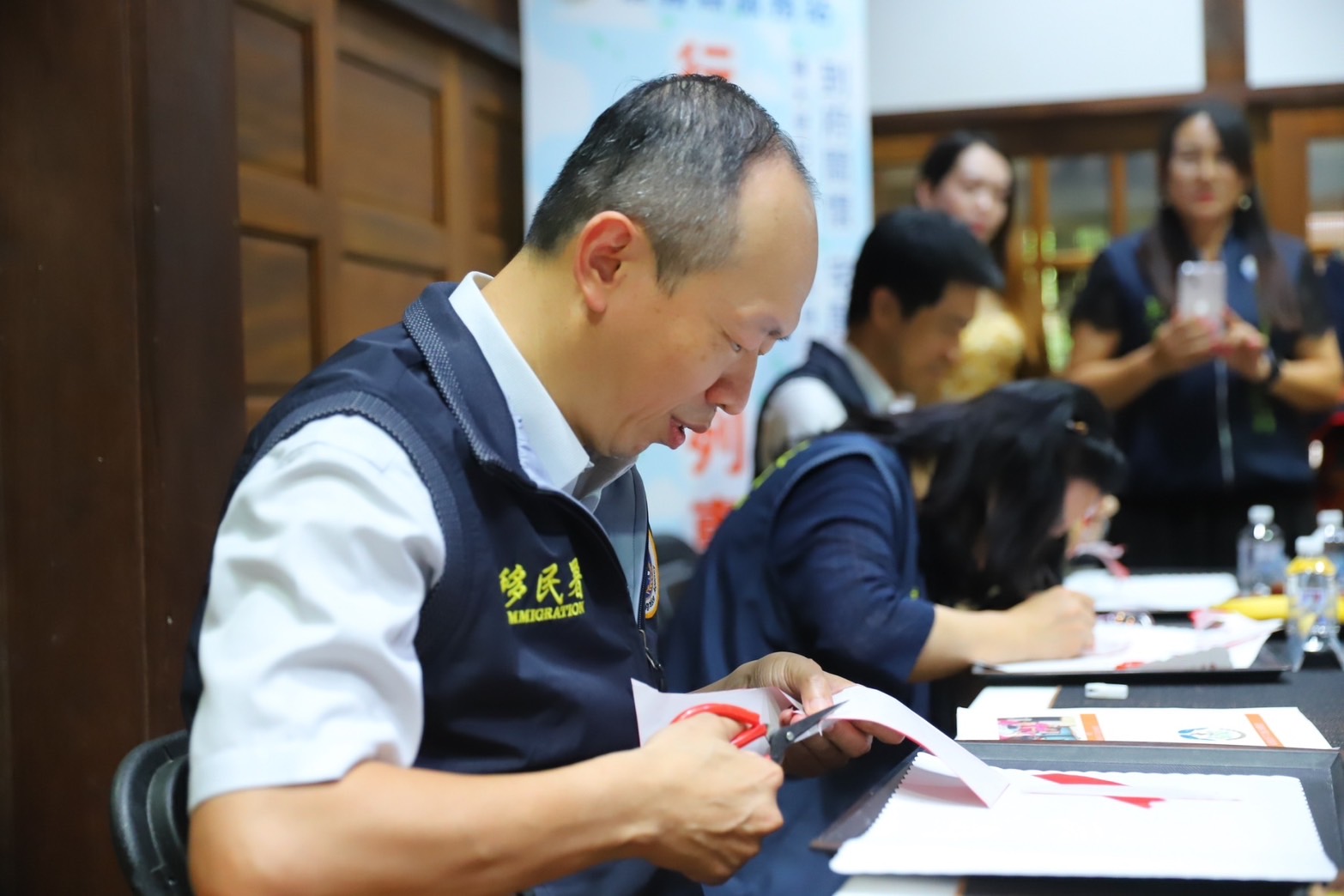 移民署謝文忠主任祕書訪視嘉義縣青翼文化產業協會，體驗剪紙藝術。（移民署提供）