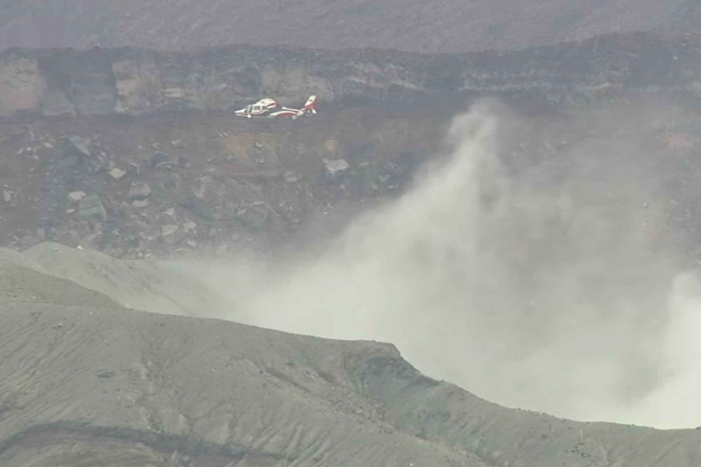 警方下午在阿蘇中岳火山口附近發現疑似墜落的機體,正前往搜救。(翻攝自RKK NEWS DIG YT)