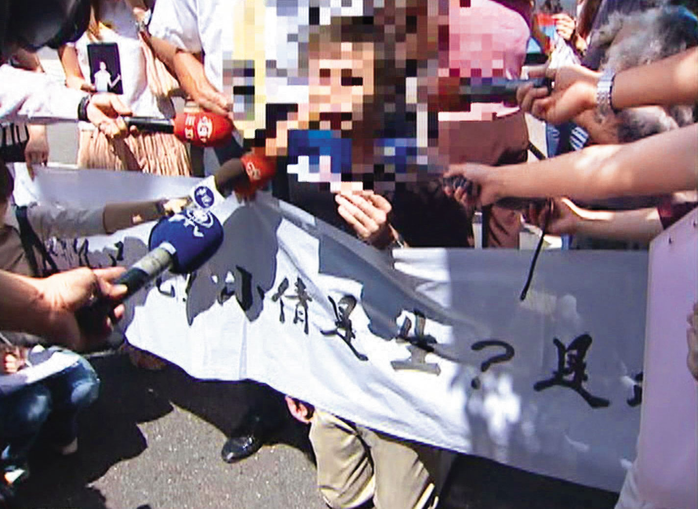 黃女家人拉起布條走上街頭，在媒體鏡頭前下跪哭喊求助。（東森新聞提供）