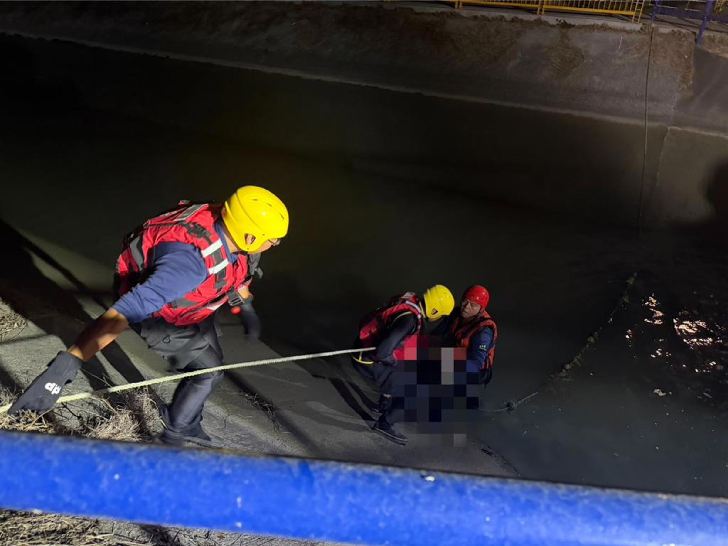 消防救難人員在嘉義新港鄉月眉段台塑中洋子廠附近發現男童遺體，利用繩索將遺體拉上岸。（翻攝畫面）