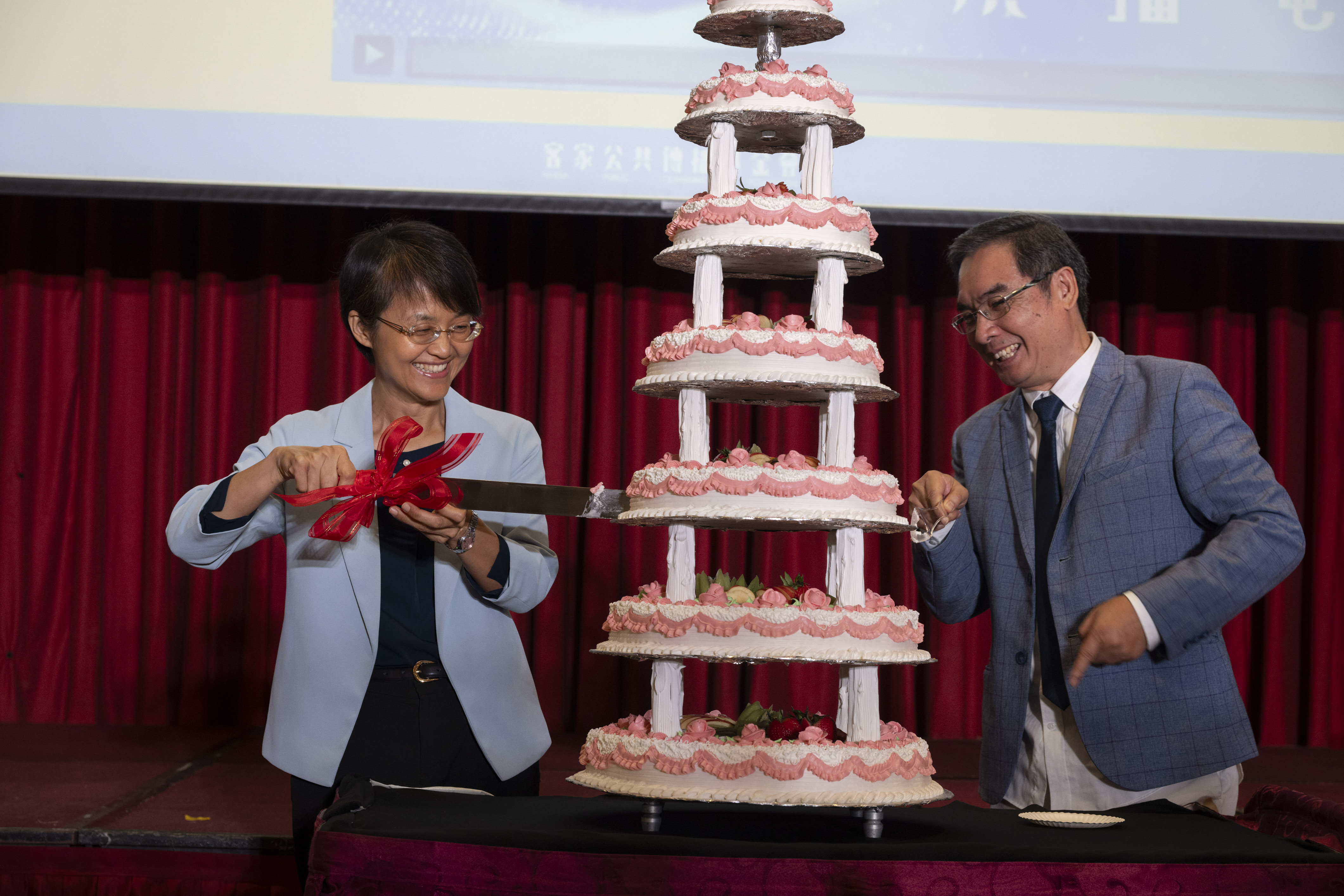客家委員會主委古秀妃(左)及客家公共傳播基金會董事長陳邦畛(右)俏皮切下7層生日蛋糕與貴賓同樂。