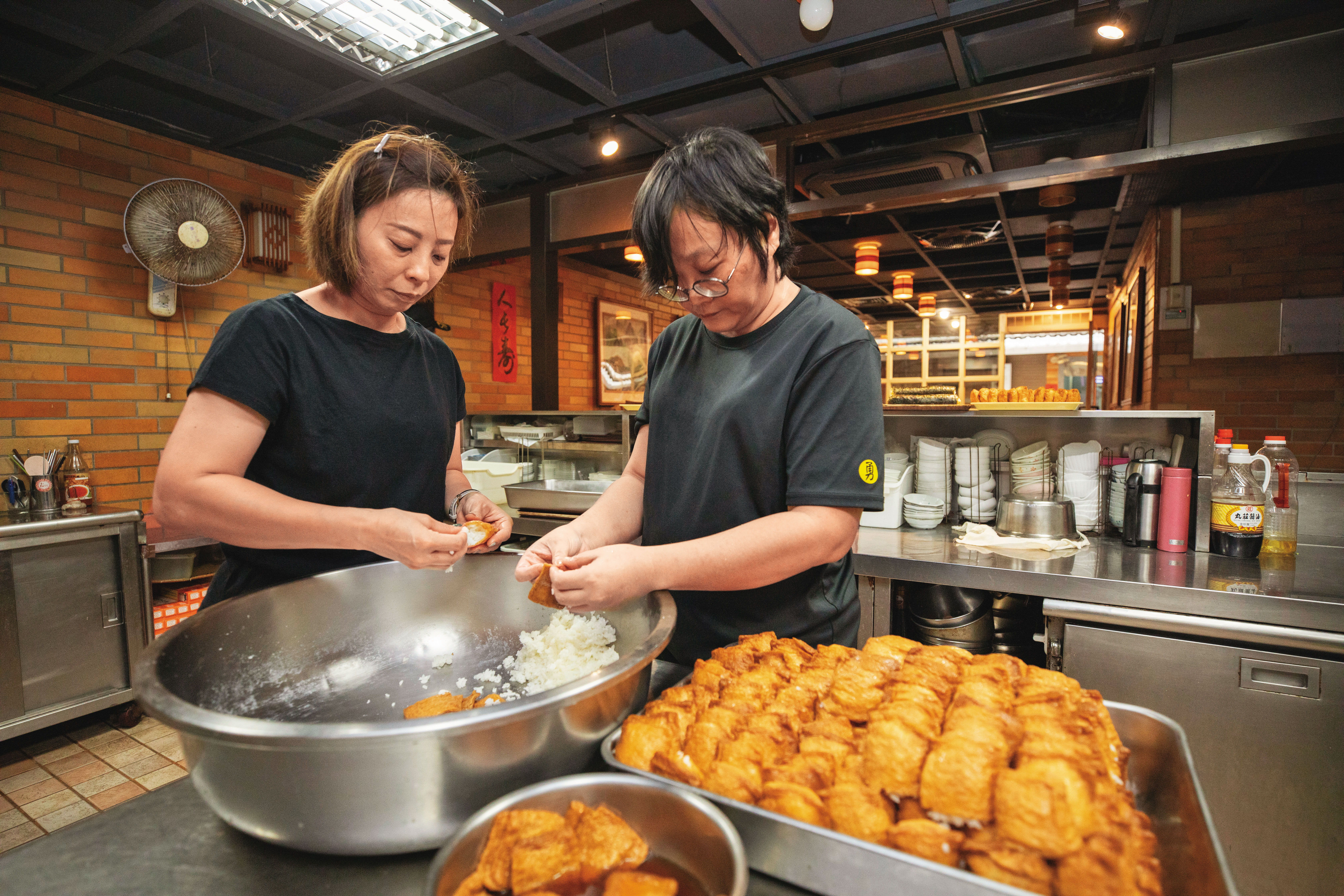 現在小巷亭主要由大女兒陳孟君（左）主掌，多年在店內四處支援的她連包壽司也游刃有餘。