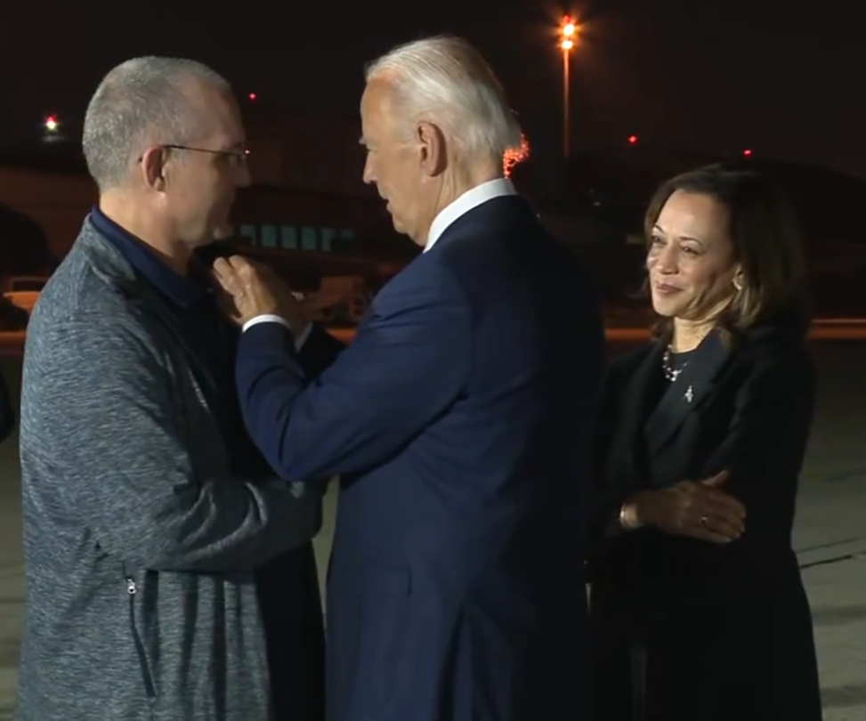 美國總統拜登(中)和副總統賀錦麗(右)向自俄羅斯返國的囚犯致意。(翻攝自X@POTUS)