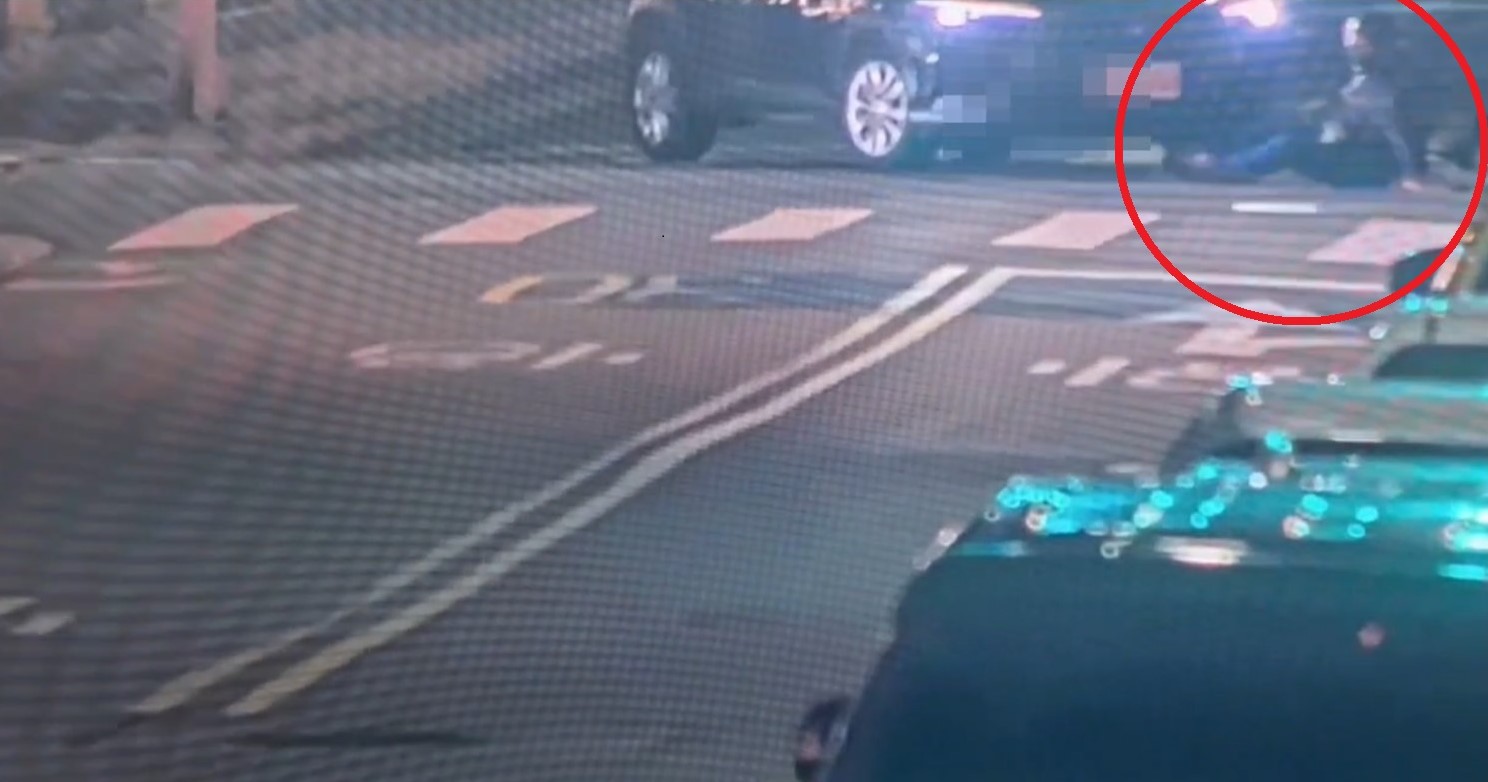 徐男酒後騎乘電動滑板車與Uber計程車發生碰撞，徐男（紅圈）隨即跌坐在地。（翻攝畫面）