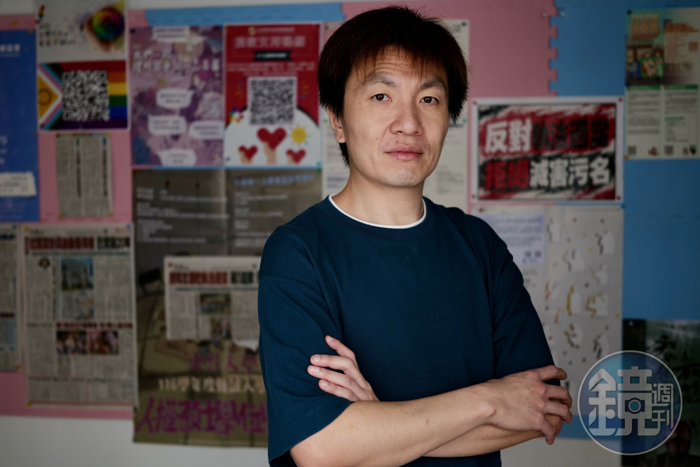 針對近日爭議，台灣同志諮詢熱線協會副秘書長彭治鏐站在「反對執法過當，拒絕減害污名」標語前。