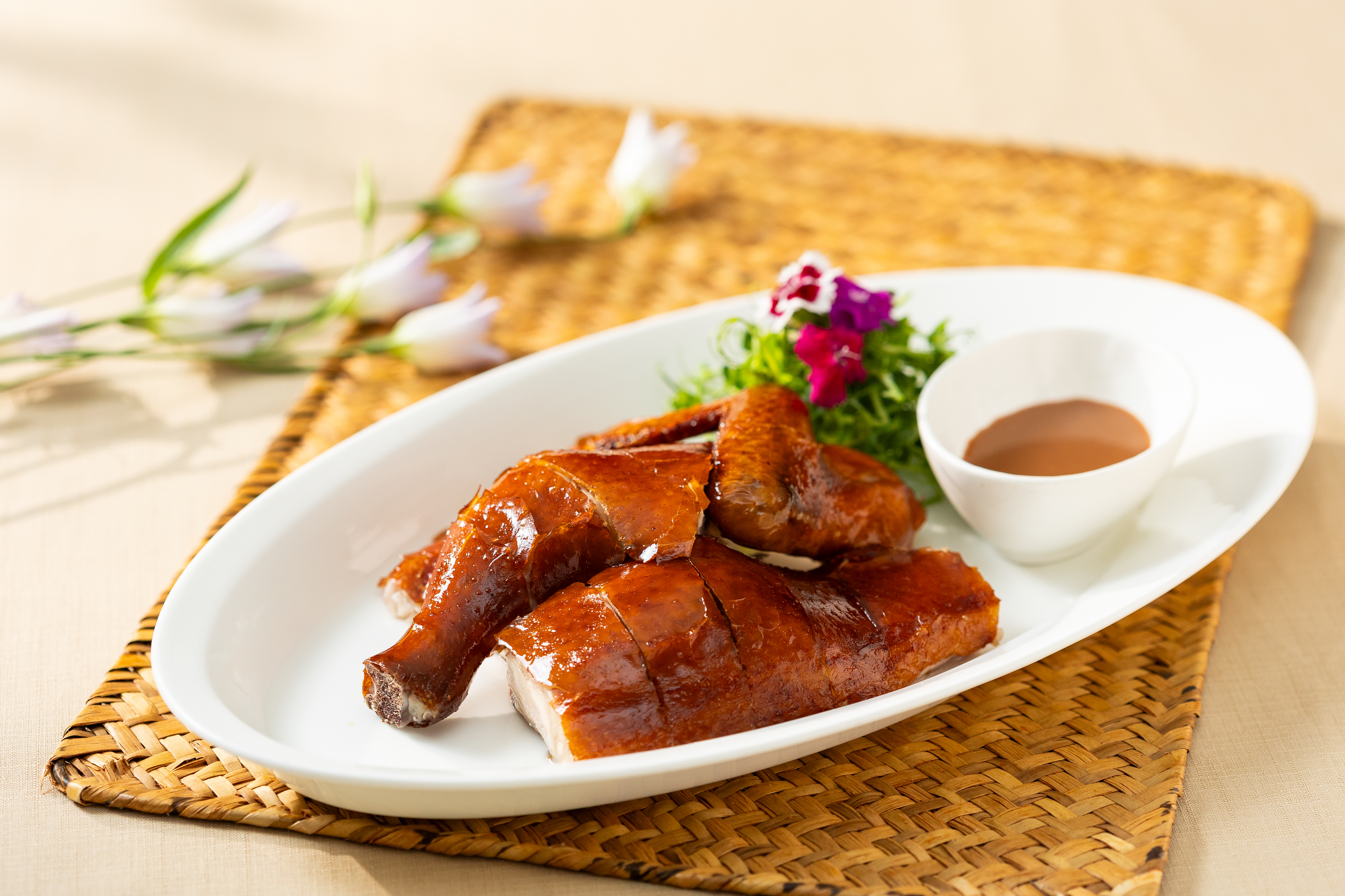 「南乳吊燒雞」承襲粵式燒臘技藝,先以南乳醃汁入味,再以慢火烘烤至外皮金黃酥脆,搭配紅豆腐乳沾醬享用,風味濃郁醇厚。