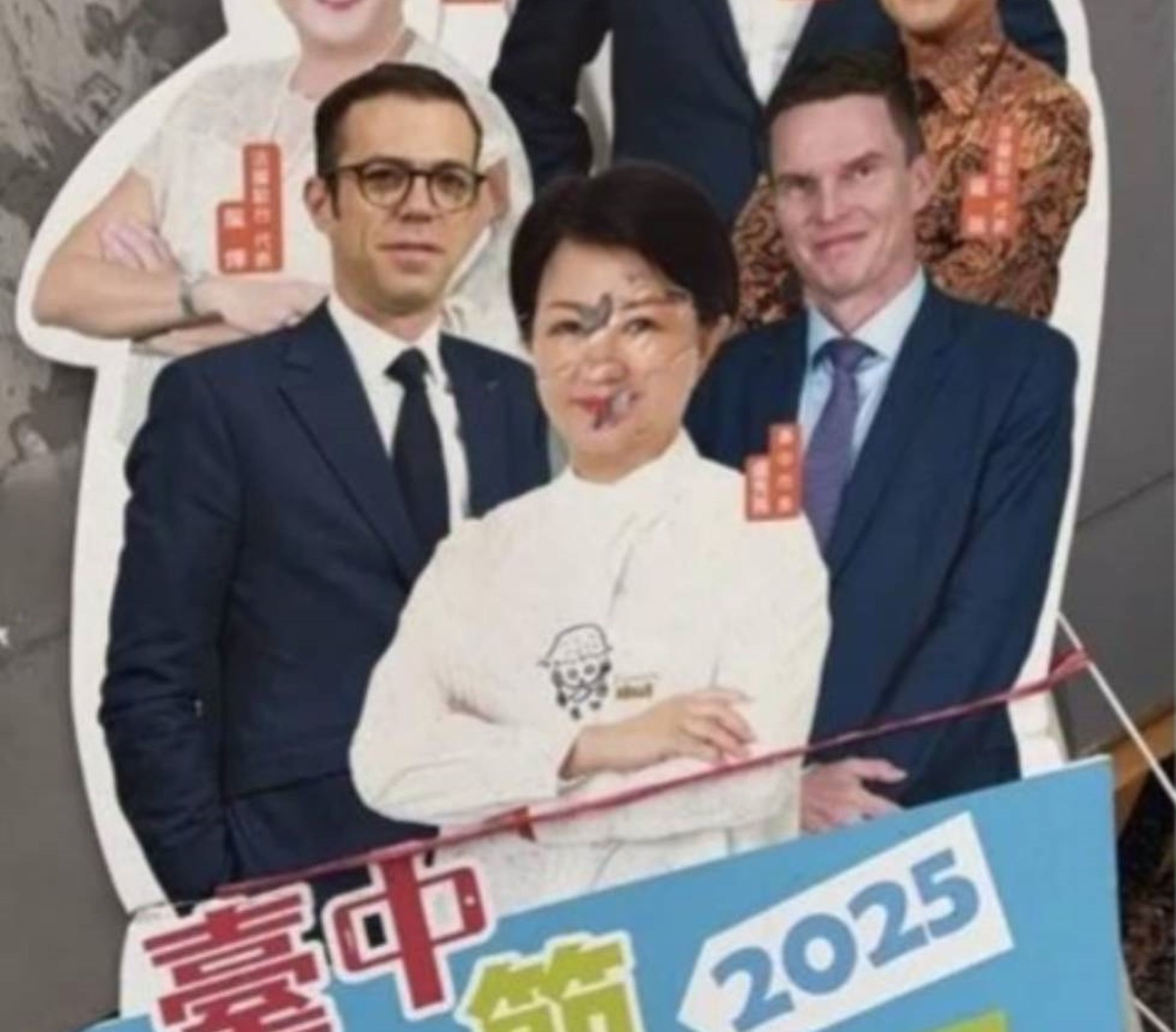 黃女發文附台中購物節人形立牌廣告，其中盧臉部有3個疑似彈孔穿越。（翻攝網路）