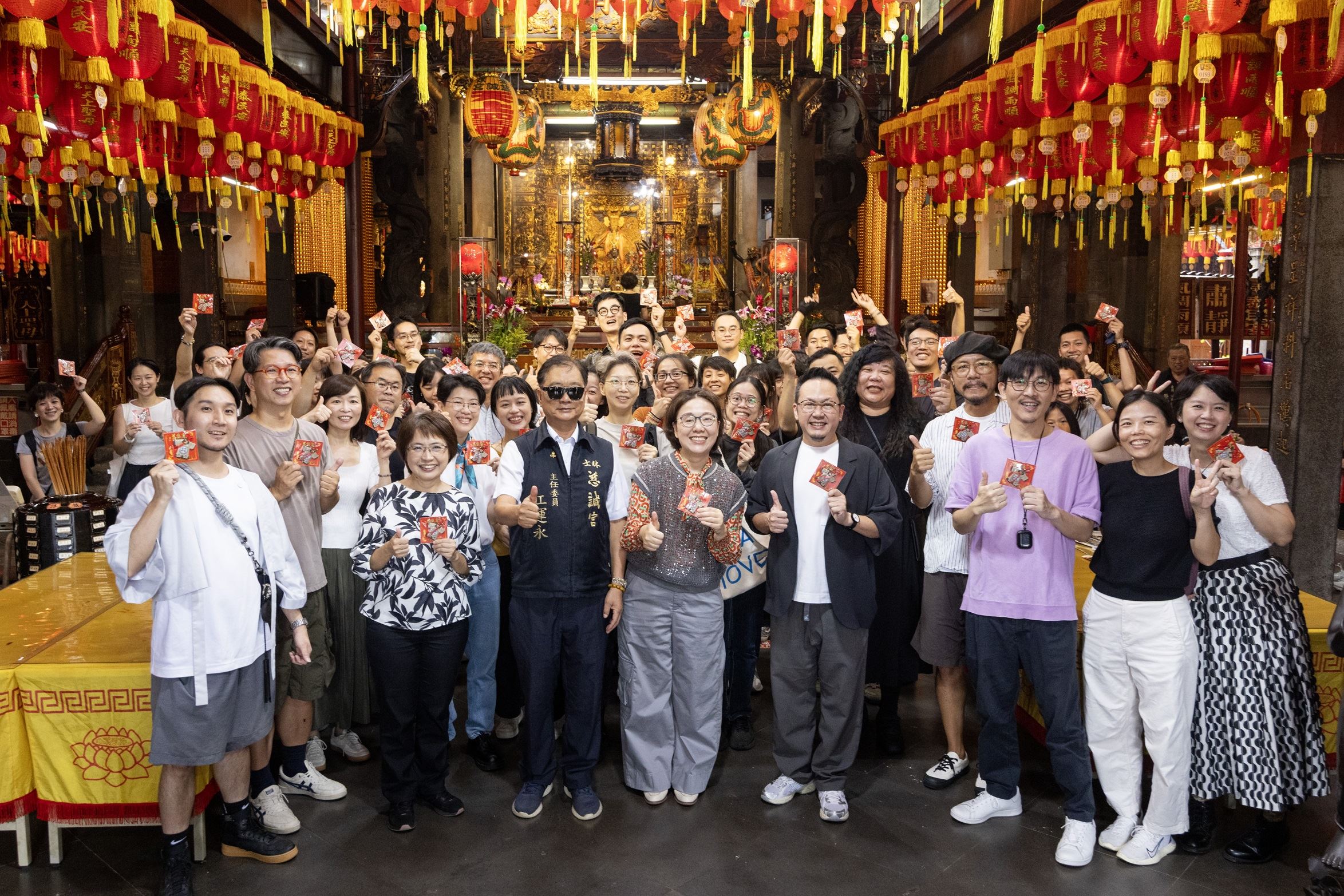 「We TAIWAN」參與團隊手持慈諴宮主任委員江運永代表廟方致贈的「小神衣」，期盼活動一切順利、收穫滿載。（文化部提供）