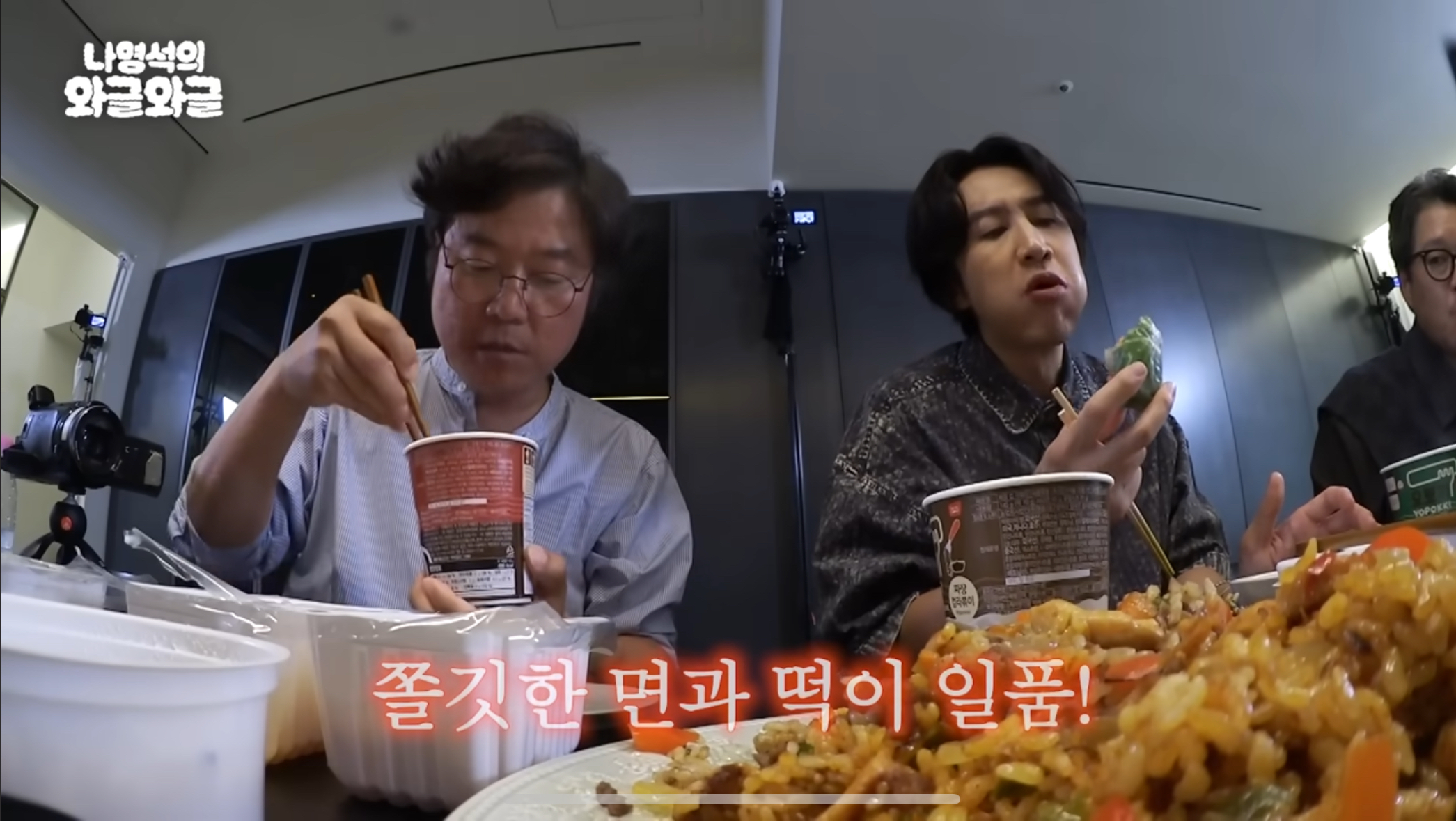 韓國速食辣炒年糕置入製作人羅暎錫（左）的節目《羅暎錫的吵吵鬧鬧》，他與來賓李光洙吃得津津有味。（翻攝自YouTube畫面）