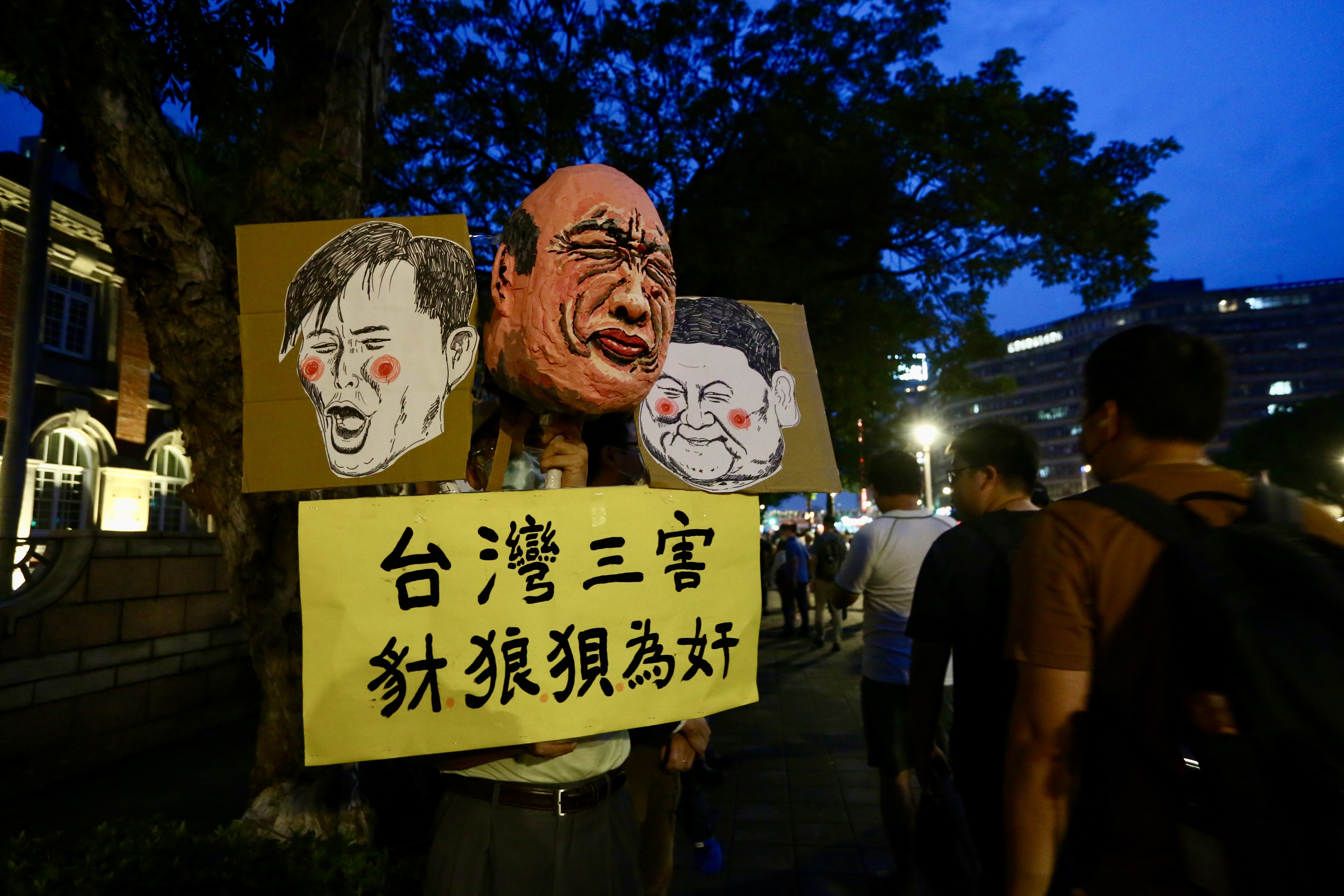 民眾舉著立委的肖像畫稱是台灣三害。