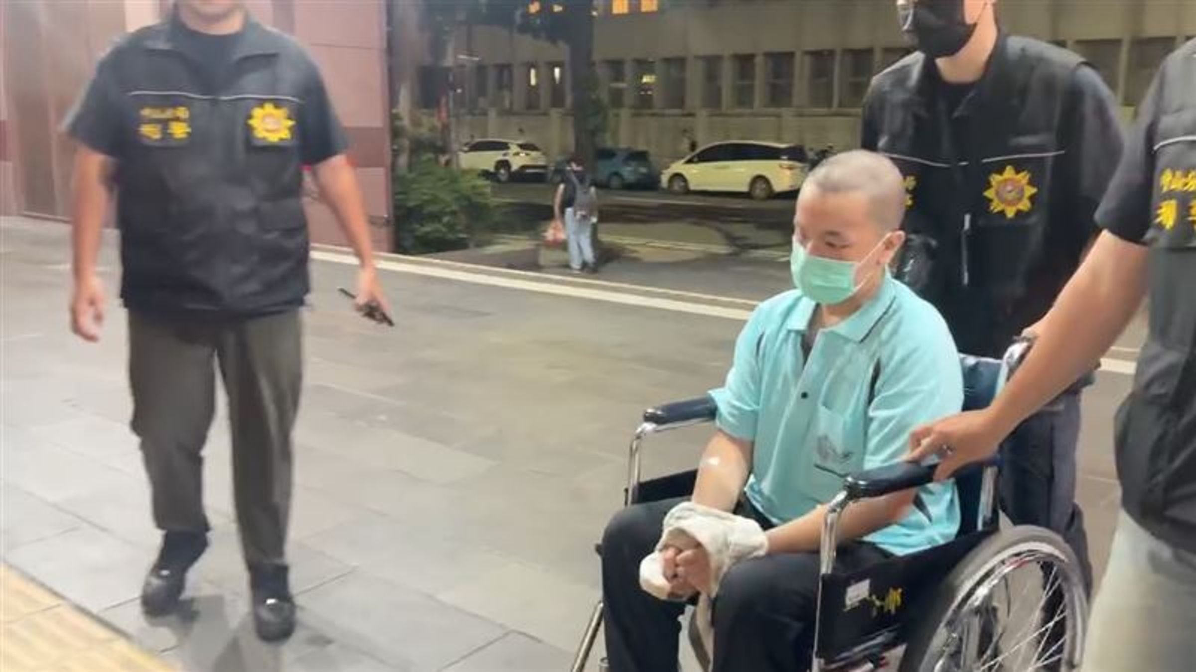 涉嫌動手行凶的黃男經醫院治療出院後，昨坐著輪椅遭警方移送北檢。（翻攝畫面）