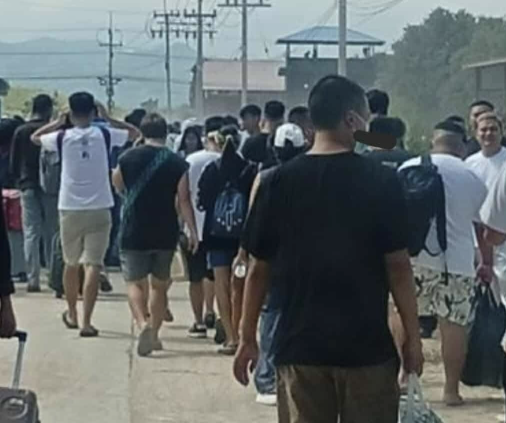 逃離人潮沿著道路湧出園區，許多人背著包包、拉著行李，隊伍綿延不絕。（翻攝X@OoKoLinn3）