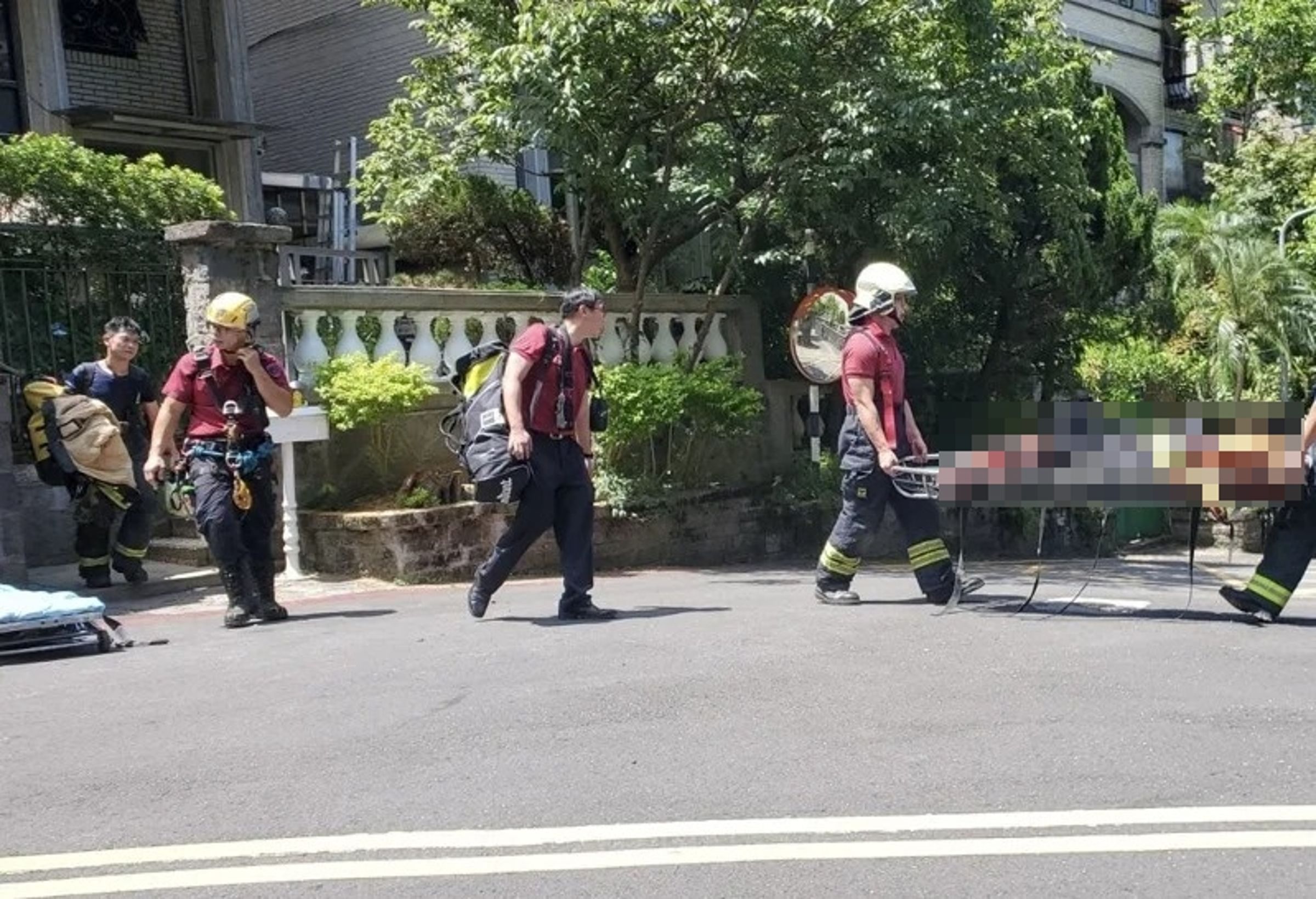 1名北市府委外廠商捕蜂員作業時意外被吊掛在樹上,救下來時已無生命跡象。(翻攝畫面)