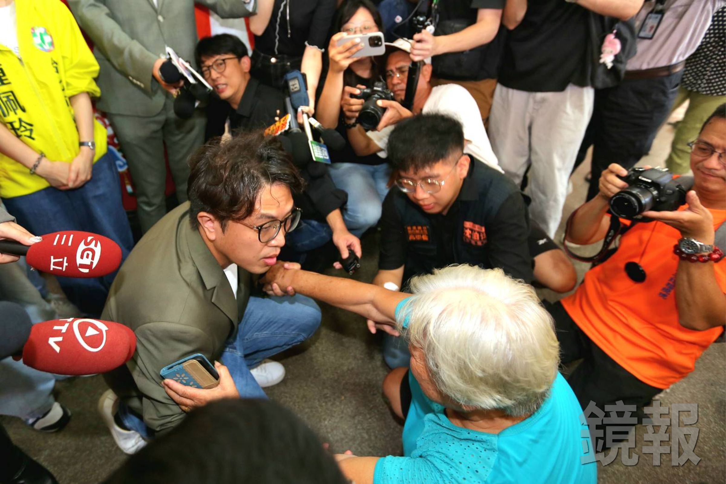 沈伯洋在社子島遇到自救會阿嬤下跪陳情，卻遭藍營酸是臨時演員。（鏡報姜永年）
