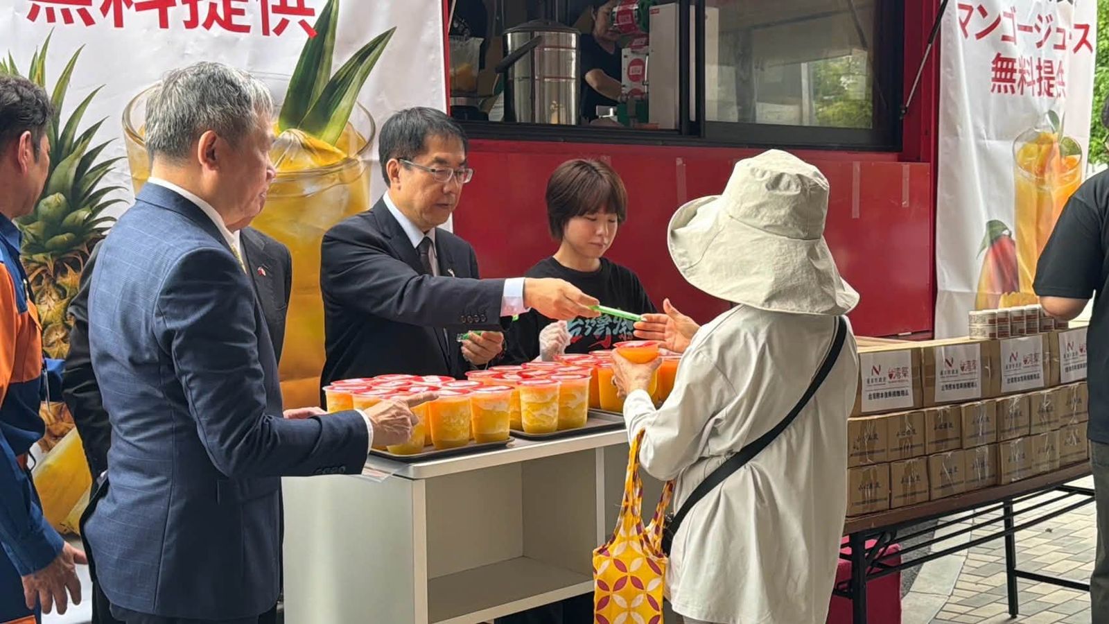 黃偉哲12日上午到熊本的台灣祭行動餐車，親手發放果汁給地震災民。（翻攝自黃偉哲臉書）
