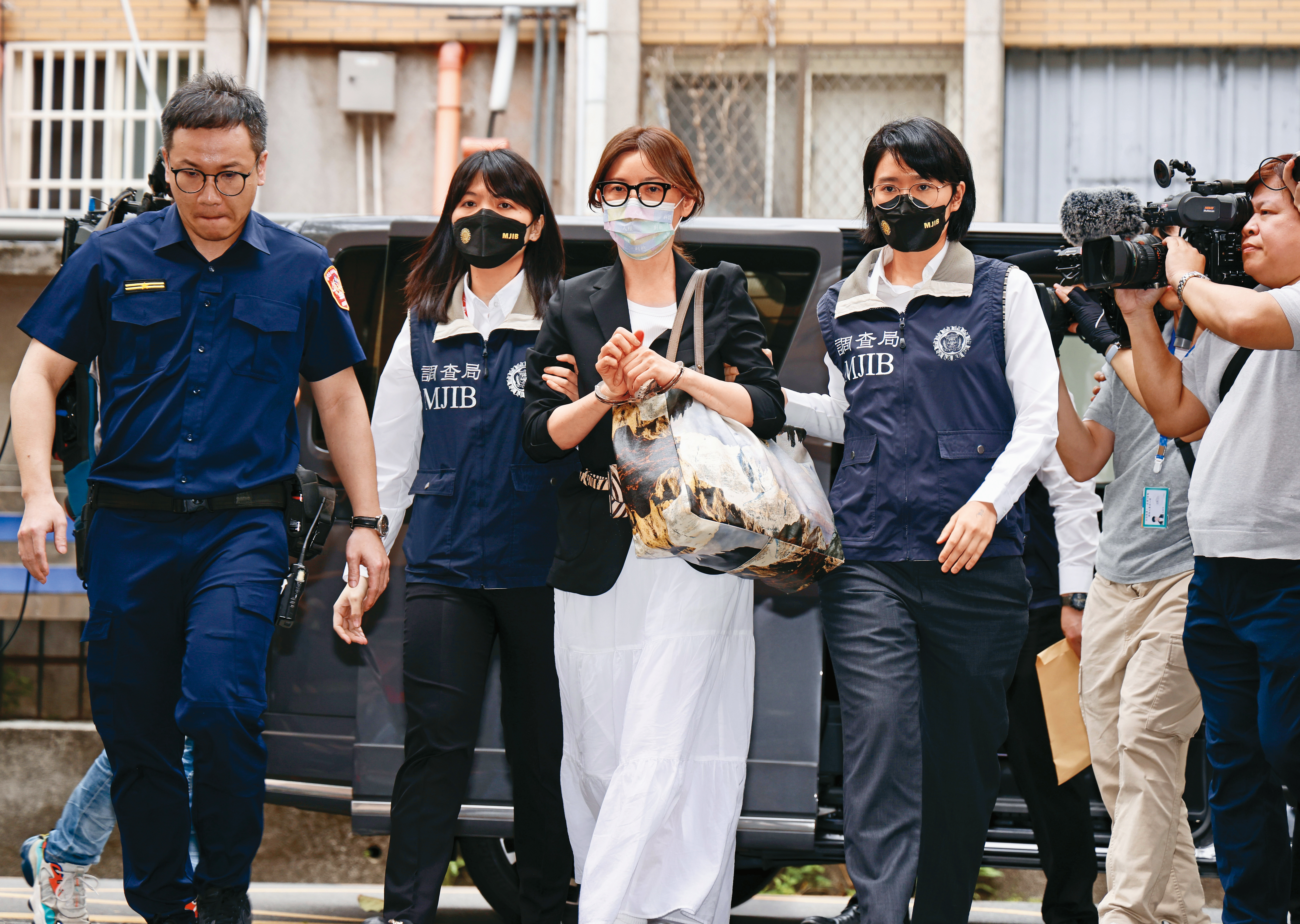 貴婦奈奈（中）與前醫師男友黃博健涉吸金上億元，潛逃加拿大7年後返台，被調查局押解歸案。