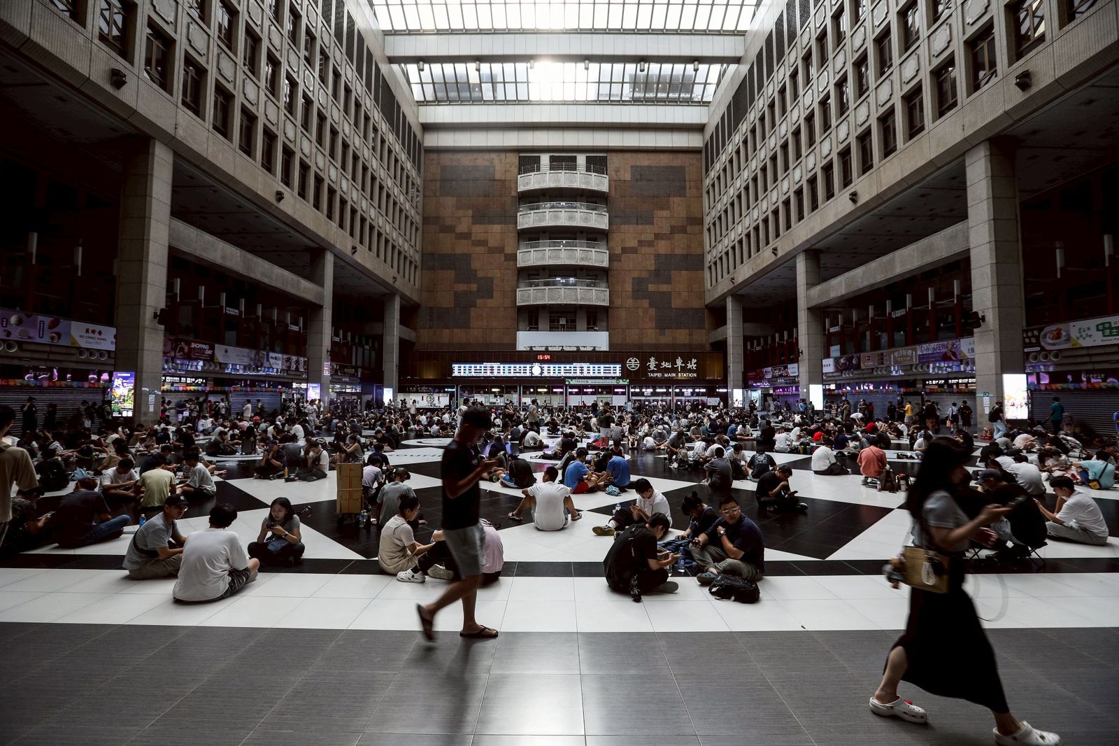 為了捕捉稀有「色違超夢」，玩家不畏風雨聚集北車。（鏡報提供，攝影鄒保祥）