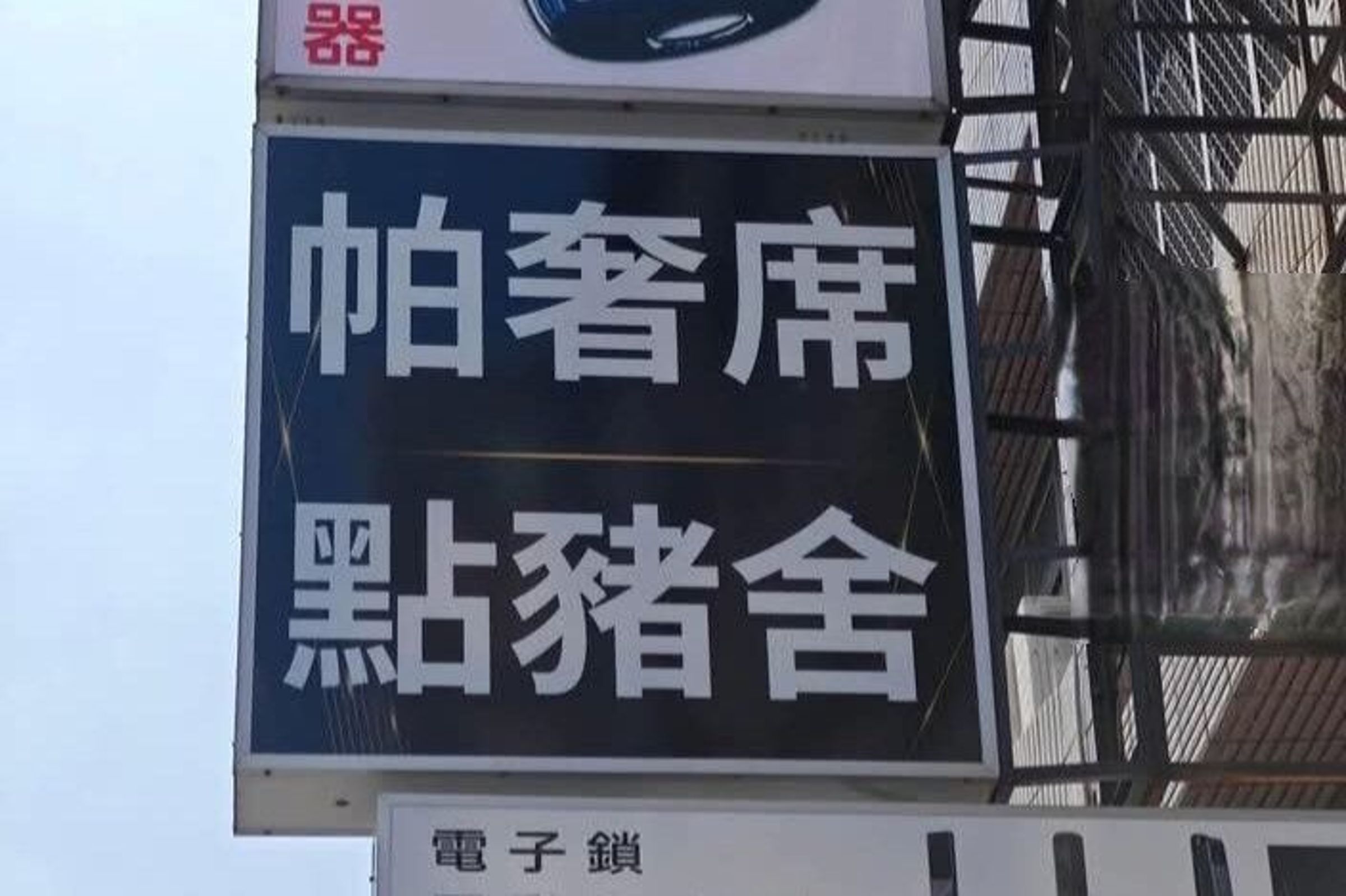 街頭店家以台語諧音設計招牌,「點豬舍」實際指的是電子鎖服務,引發網友熱烈討論,也被笑稱是「只有台灣人懂的哏」。 (翻攝自臉書/爆廢1公社)