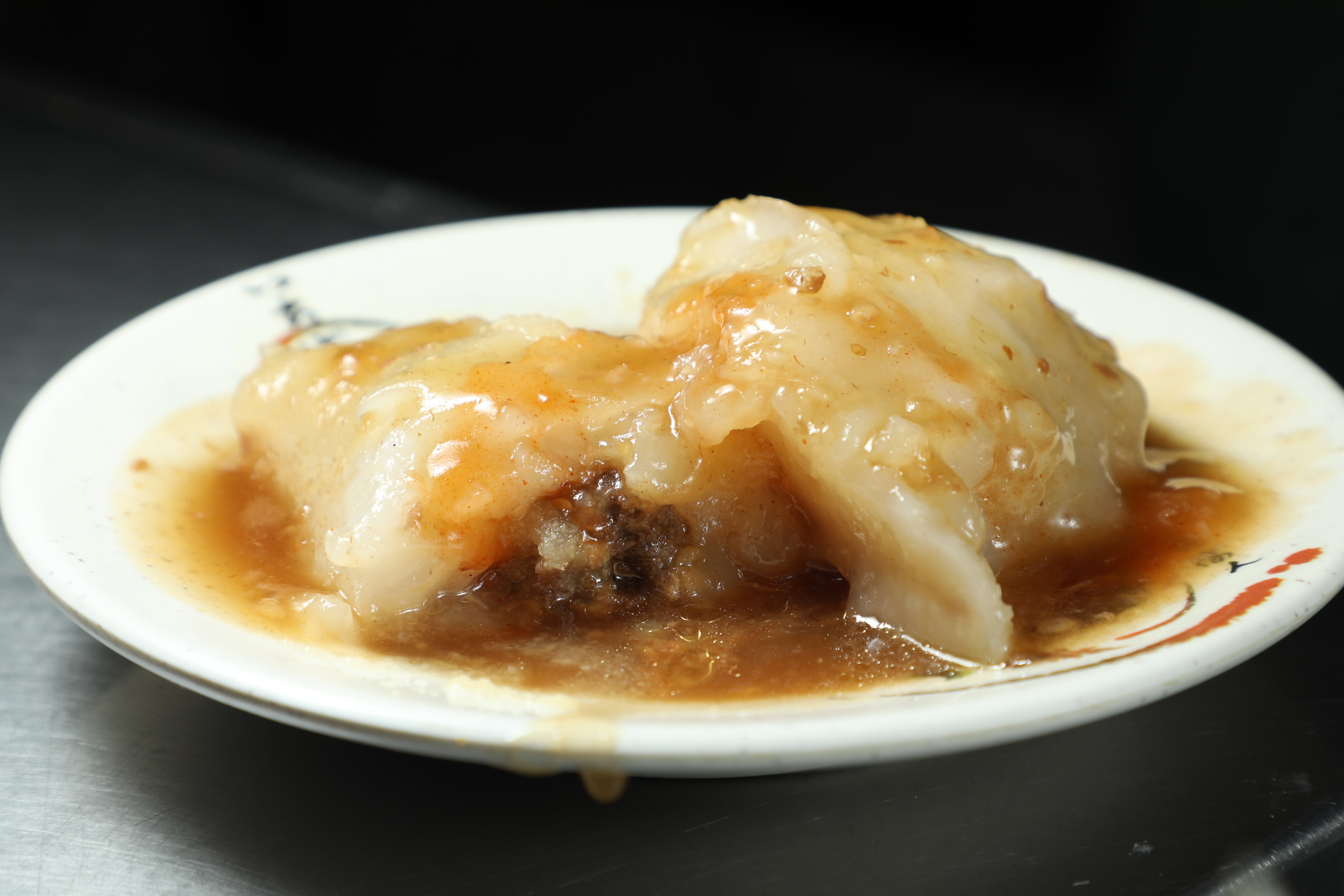 「葉記肉圓」的肉圓採用清蒸的方式，外皮厚實卻相當軟嫩，包裹細緻的肉末，搭配琥珀色醬汁與濃郁蒜汁，十分美味。（何宗昇攝）