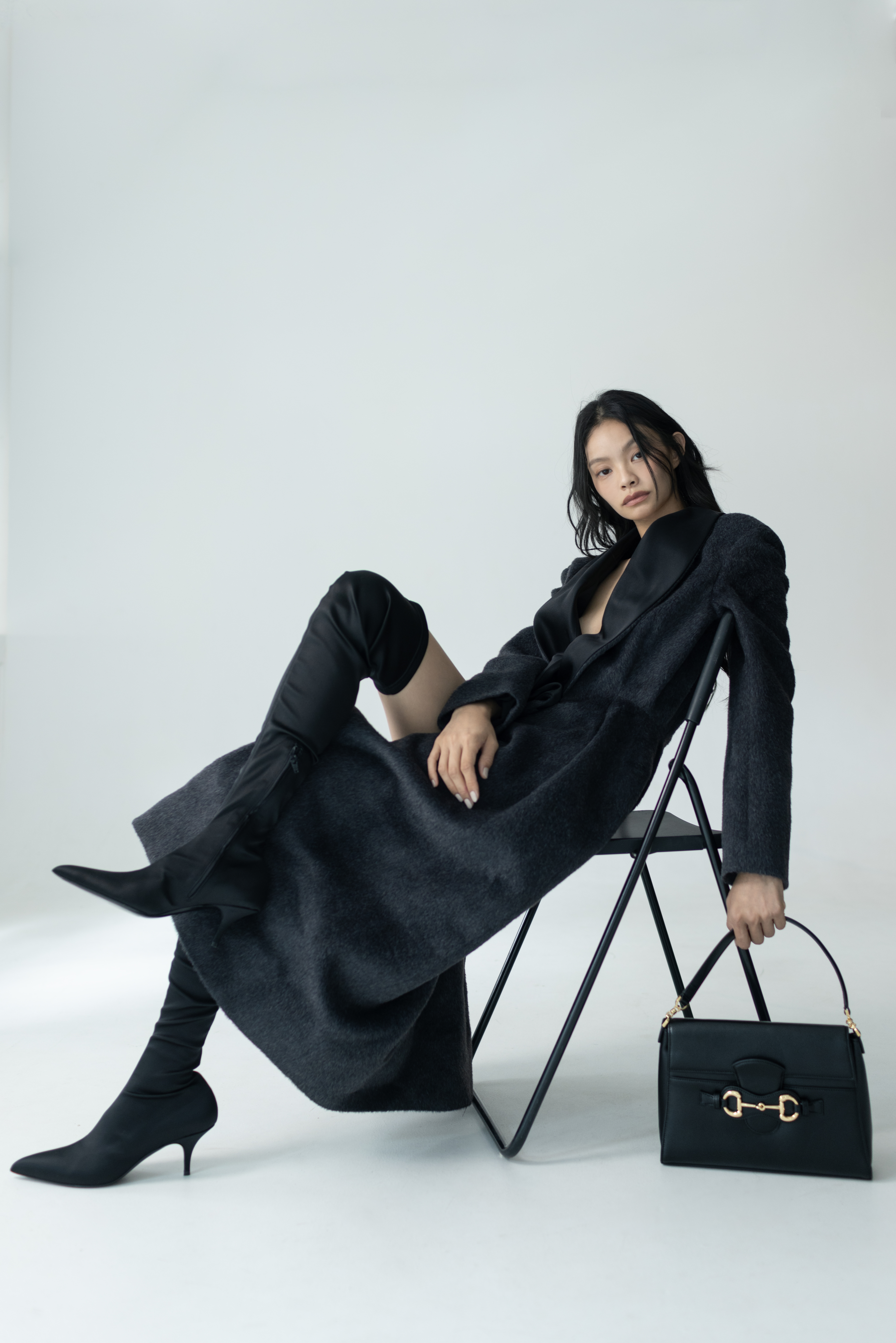 黑色小牛皮Horsebit Duomo手提包 NT$122,400 by GUCCI；初剪羊毛大衣 NT$310,000 by DIOR；SLEEK亮面過膝靴 NT$69,000 by CELINE。
