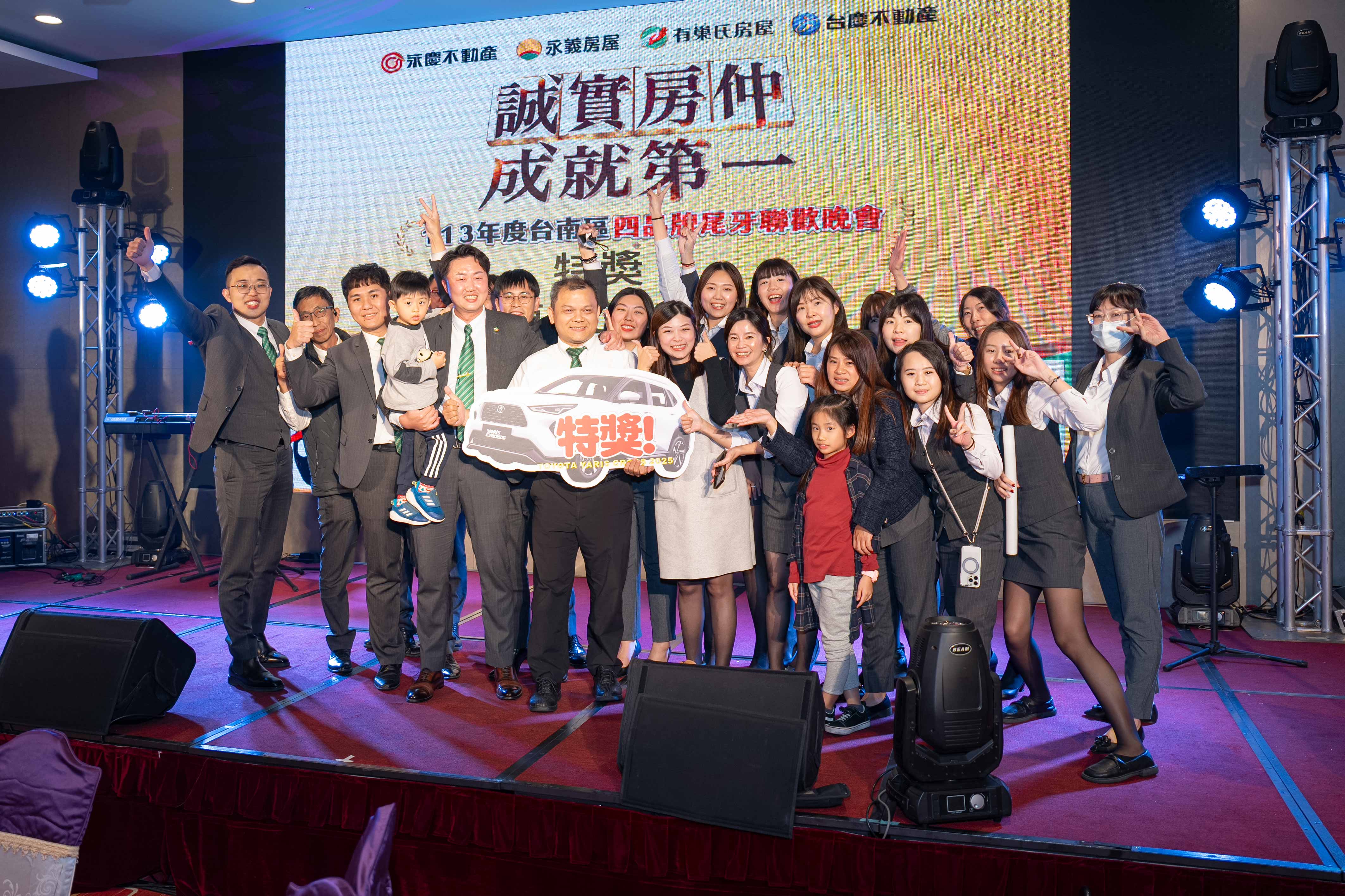 有巢氏房屋台南高鐵高發加盟店夥伴幸運抽中汽車特獎，號召全店同仁上台拍照。（永慶房產集團提供）