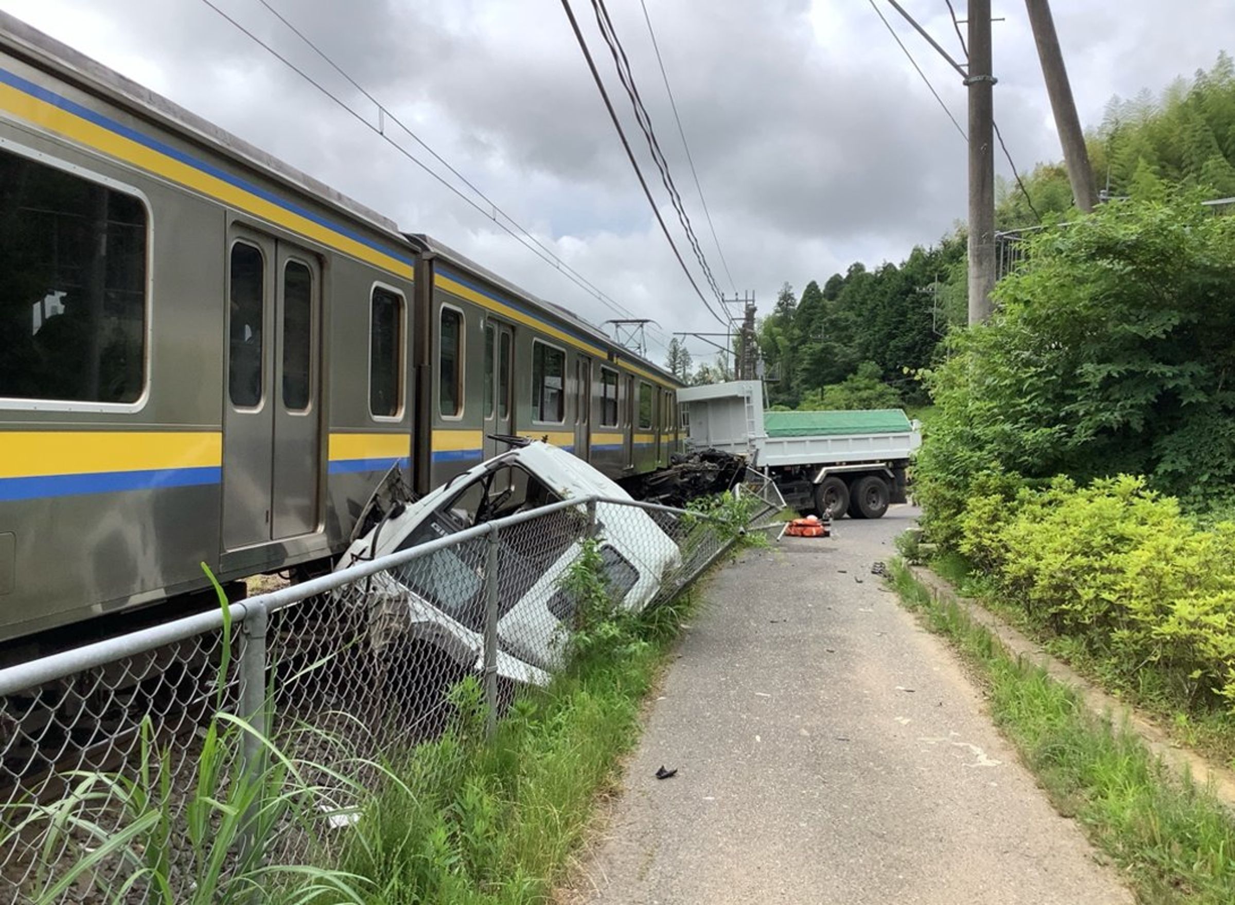卡車與JR相撞車尾分離,車頭卡在護欄與列車間,顯見撞擊力道猛烈。(翻攝X@JRE_F_Sobu)