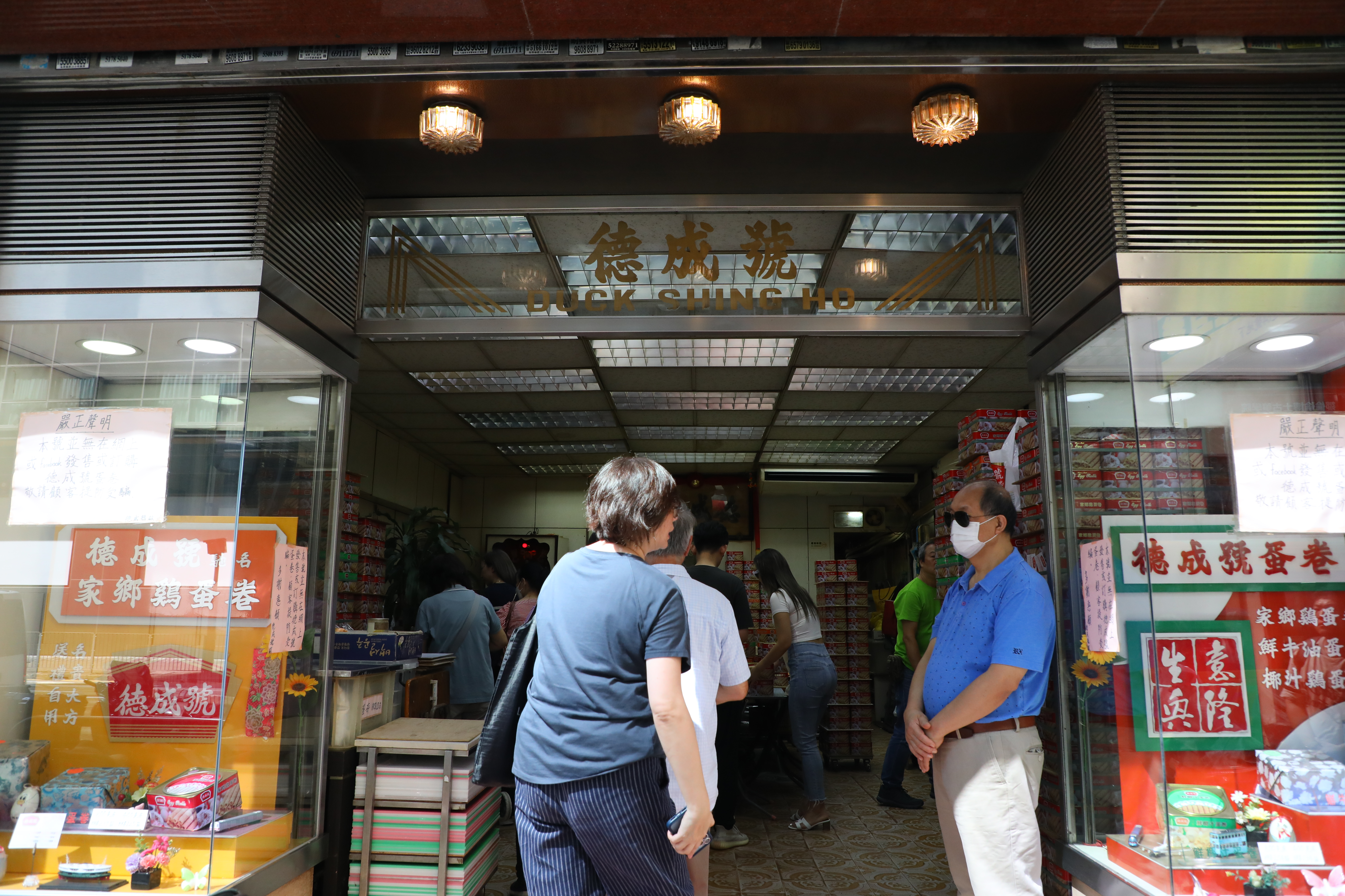 原本是雜貨店的德成號，轉型成蛋卷店也有數十年，門口兩側櫥窗展示以前的老看板。