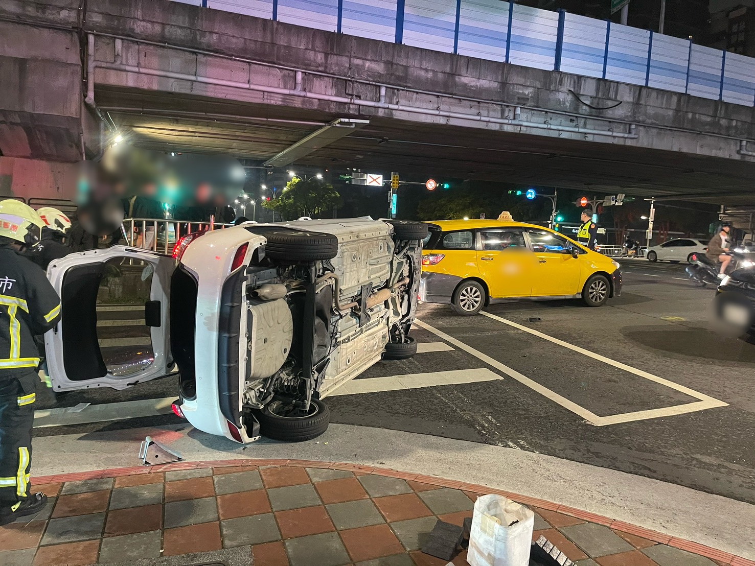 白色租賃車擦撞後翻滾一圈半,橫躺在外側車道的班馬線上。(翻攝畫面)