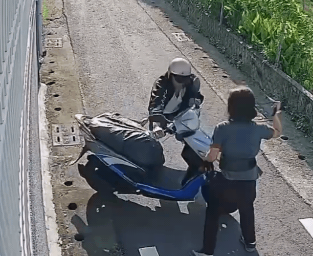 婦人撿回包包後拿起背帶對歹徒「鞭數十」，歹徒狼狽騎車逃跑。（翻攝畫面）