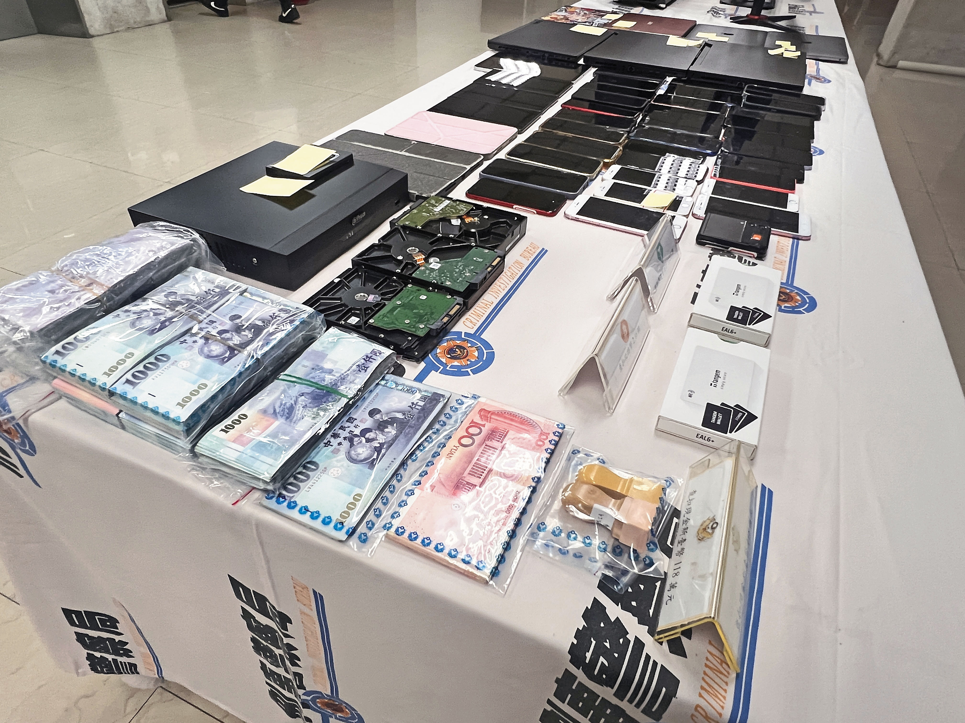 警方在黃鶴樓及共犯的工作室和住處，查扣大批贓款、手機及電腦。（刑事局提供）