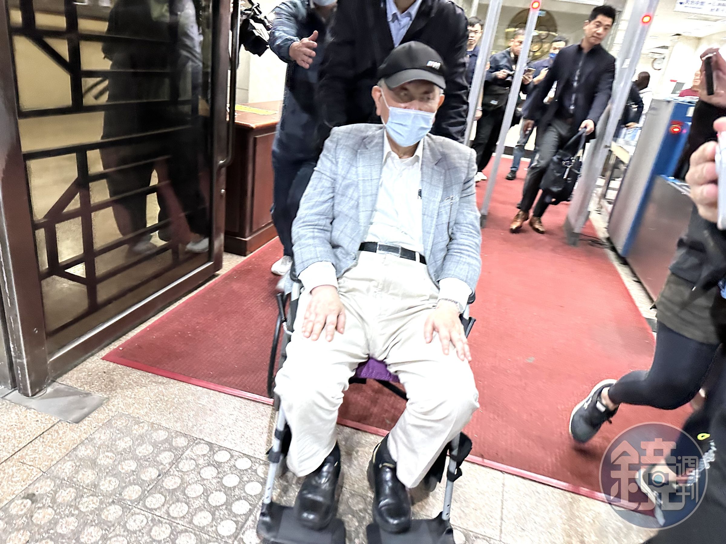 京華城案第二波偵辦，沈慶京700萬交保後坐輪椅飛快離去。